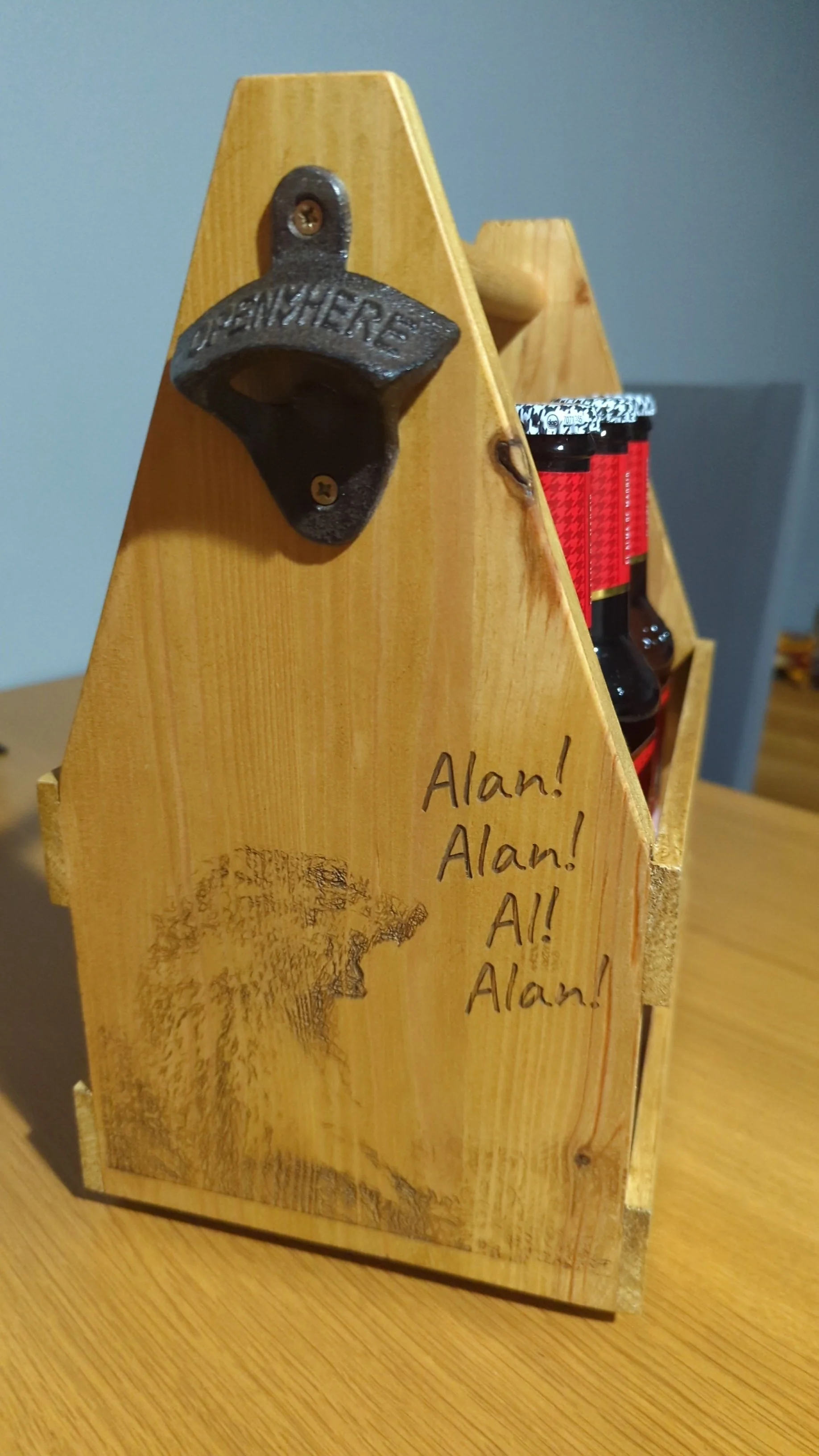 Wooden beer caddy with a black cast bottle opener. 