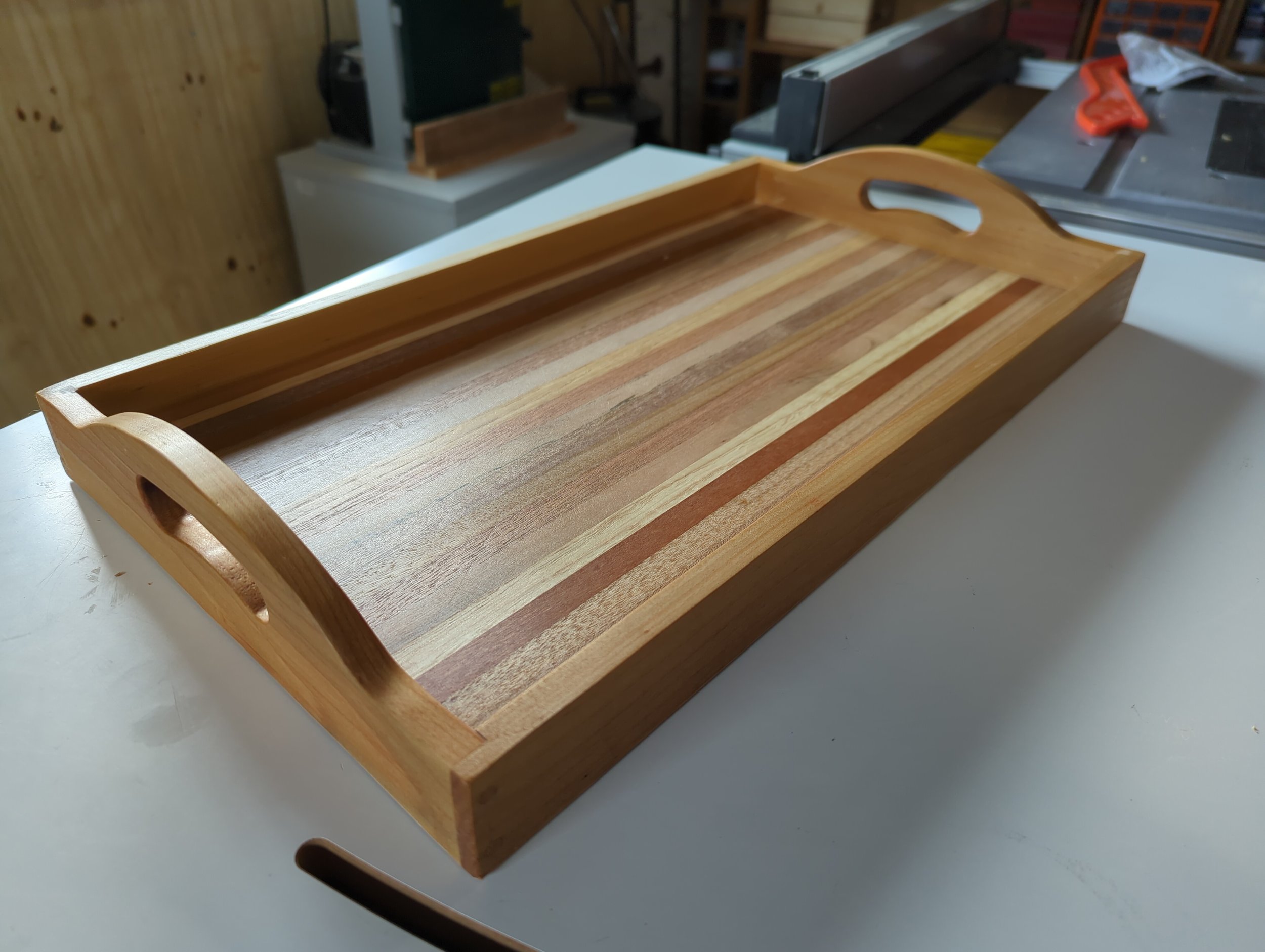 Wooden serving tray with cutout handles.
