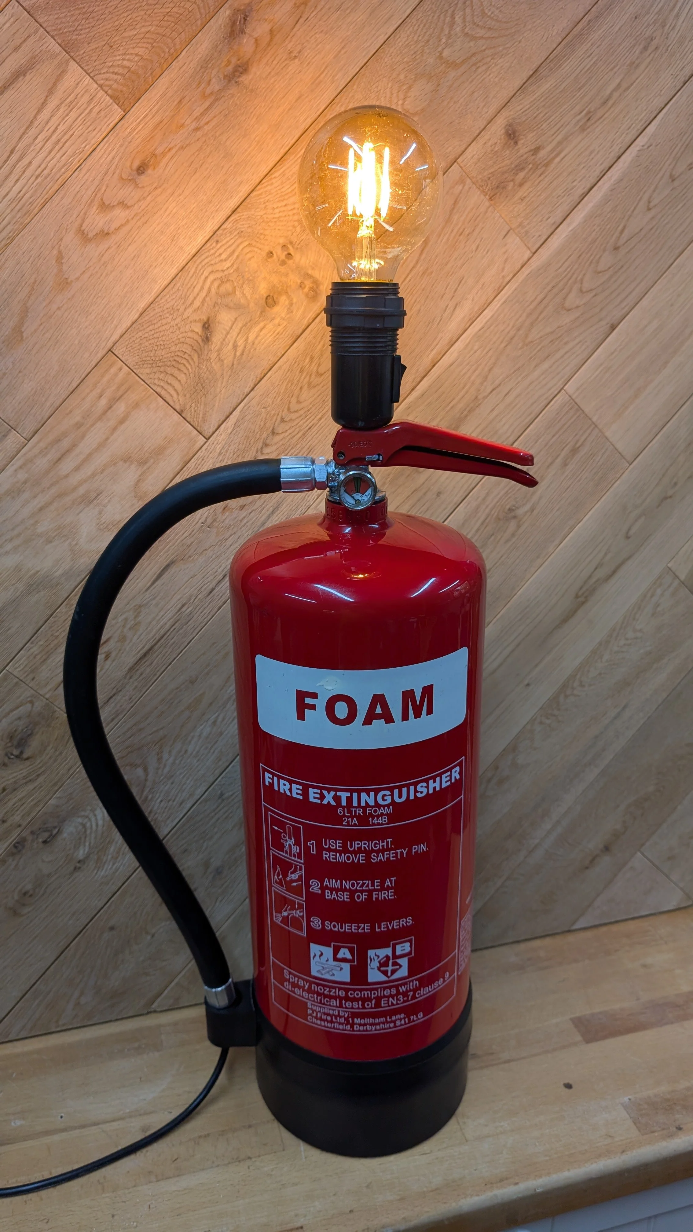A large lamp made from a decommisioned fire extiguisher