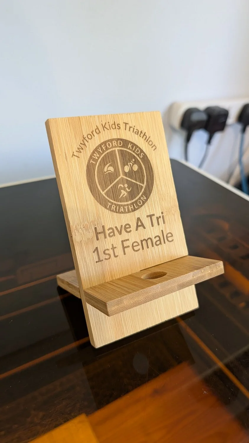 A wooden trophy/phone holder for a local triathlon company.