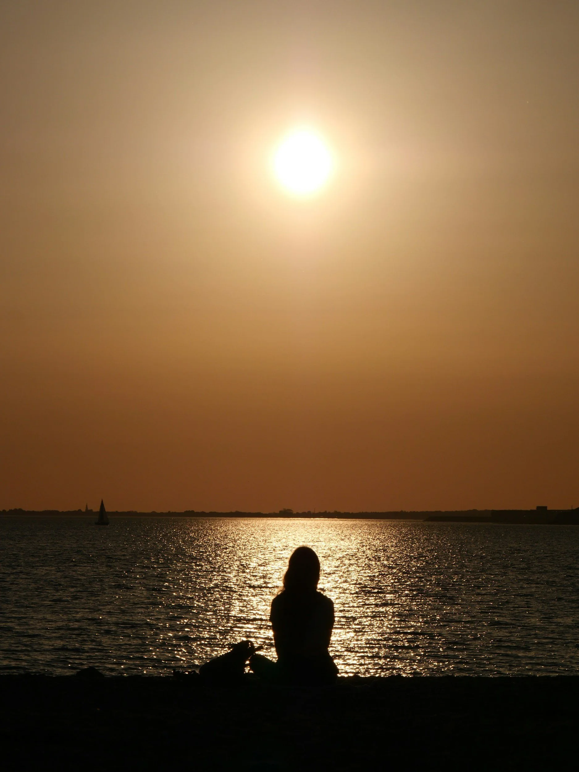 Woman looking out to sea reflecting on thoughts and emotions in a calm, supportive therapy process