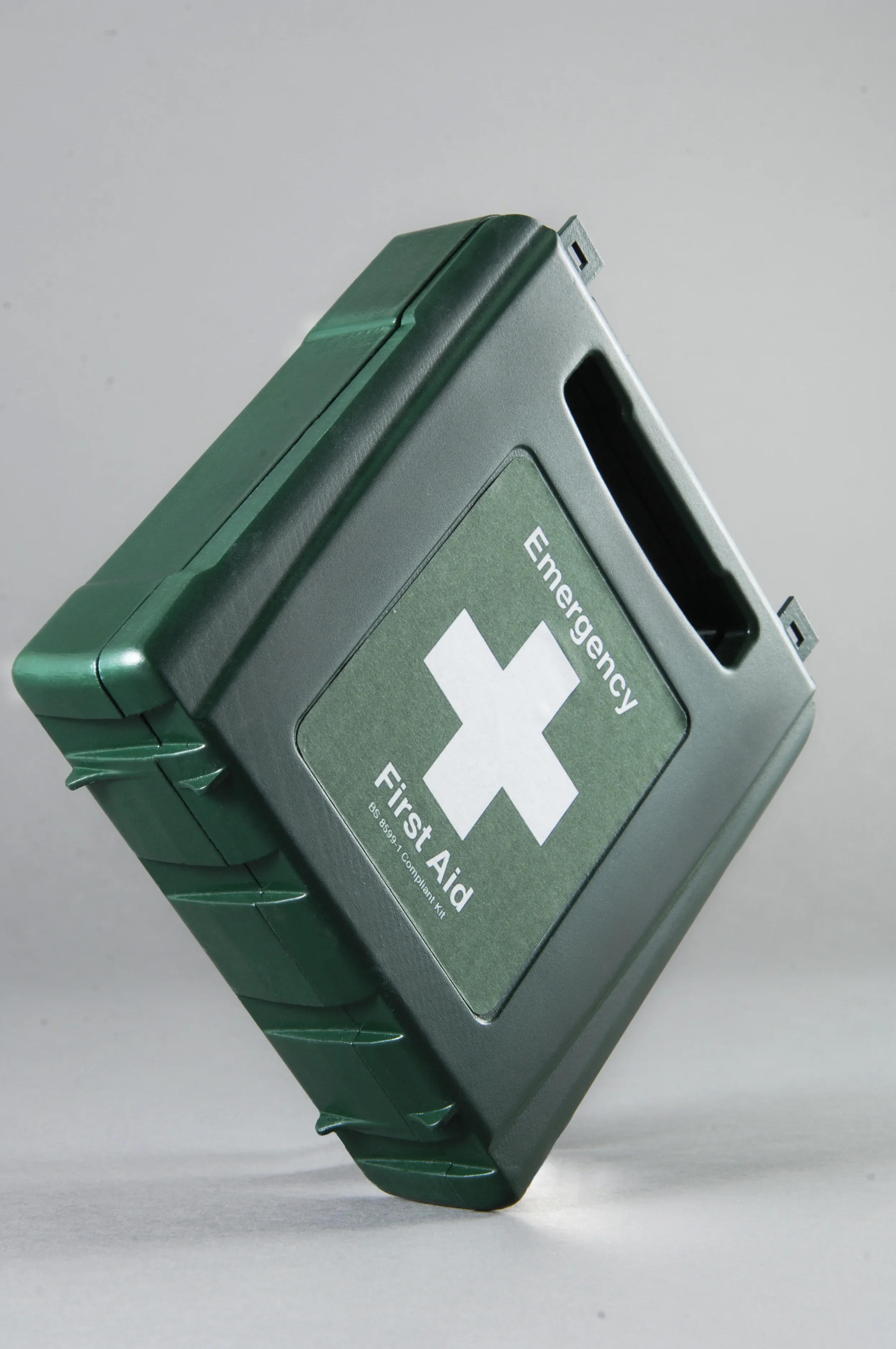 A green emergency first aid kit with a white cross symbol on the front label.