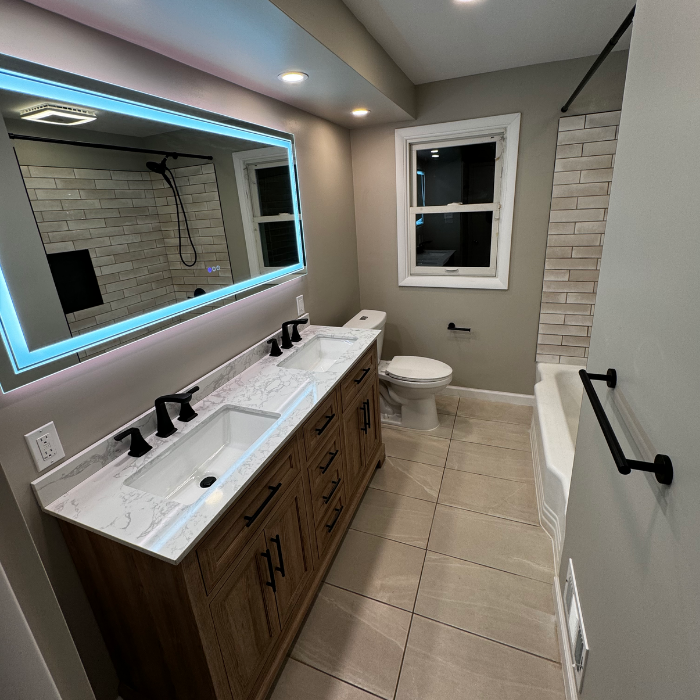 Bathroom remodelled with new vanity, tile, light-up mirror, paint, toilet, fixtures, shower, and more.