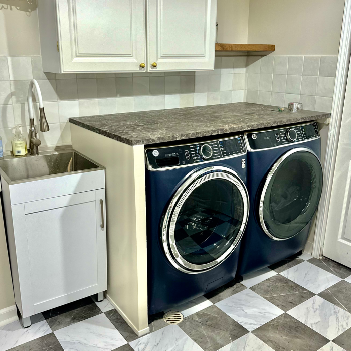 Renovation of a laundry room with new tile, cabinets, sink, shelves, layout, and more.