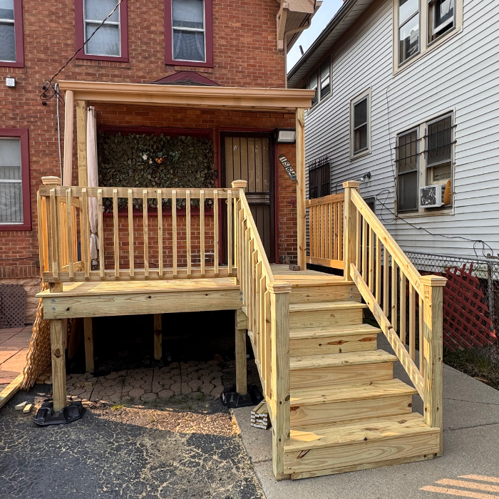 New wooden front porch and stairs attached to a home's exterior