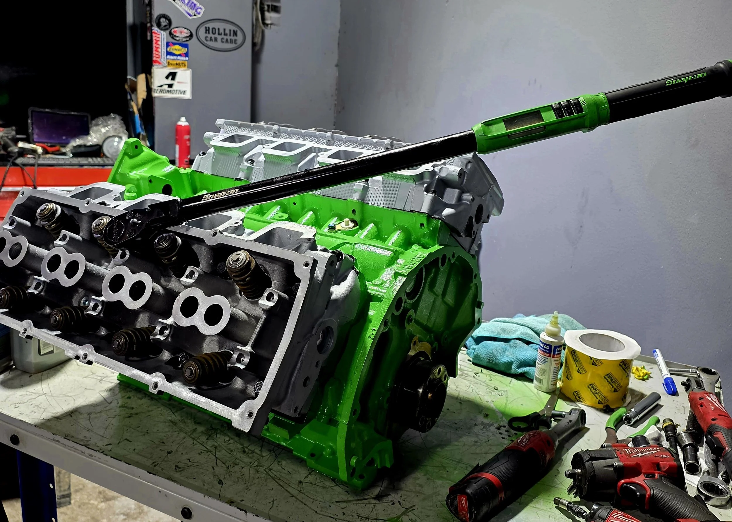 A green a grey engine with a torque wrench being built at Hollin Car Care