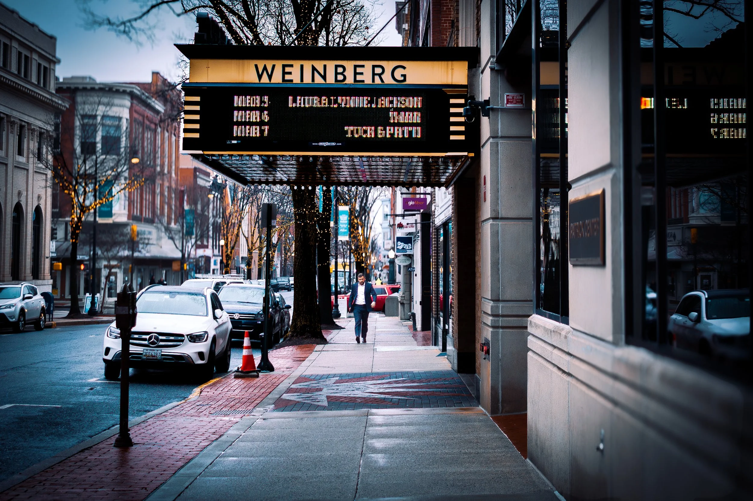 Weinberg Theater Street Scene
Street photograph of the historic Weinberg Center in Downtown Frederick, Maryland with pedestrian walking beneath the theater marquee.
