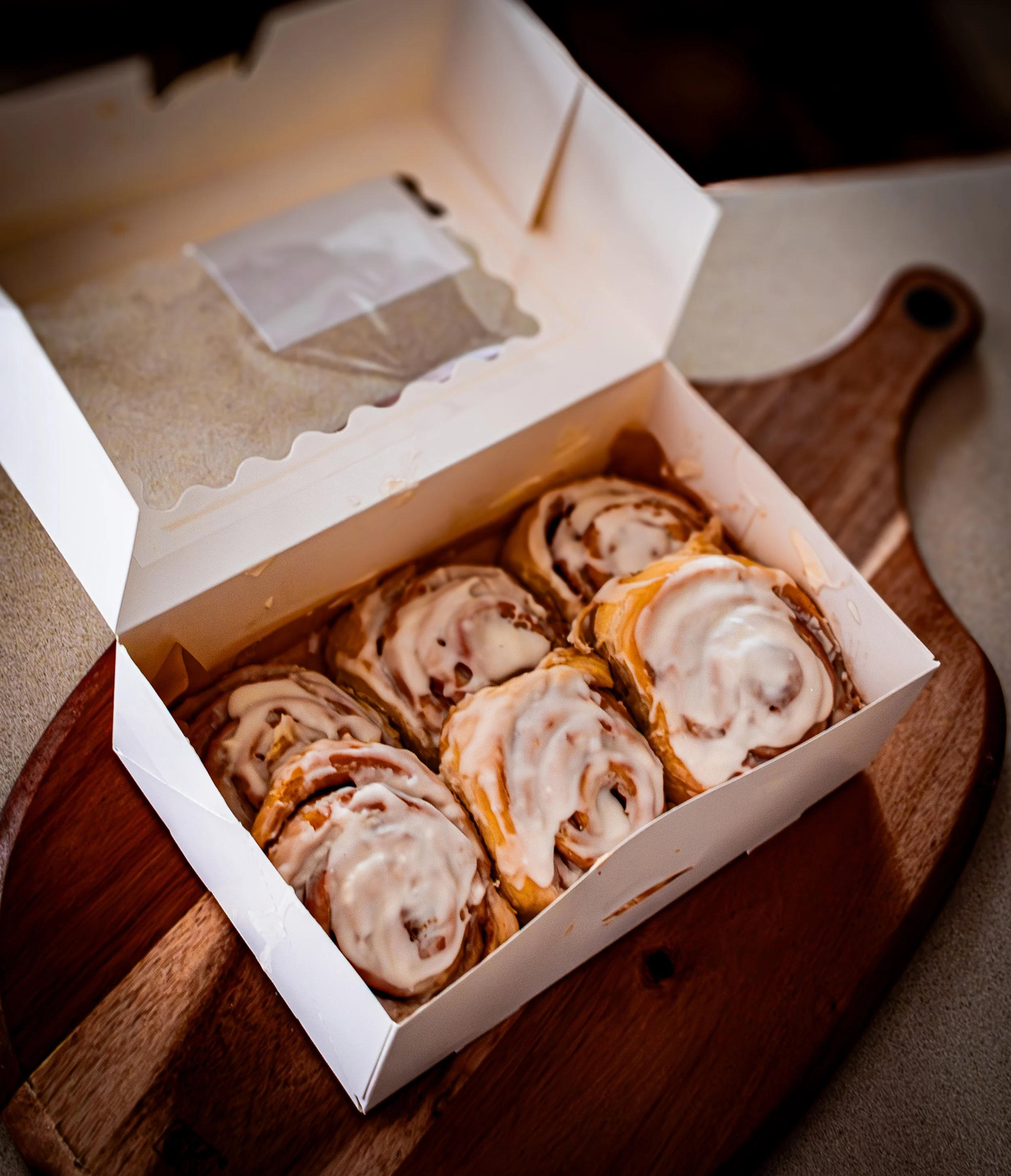 Box of freshly baked cinnamon rolls packaged for customers, small business bakery product photography, Frederick MD
