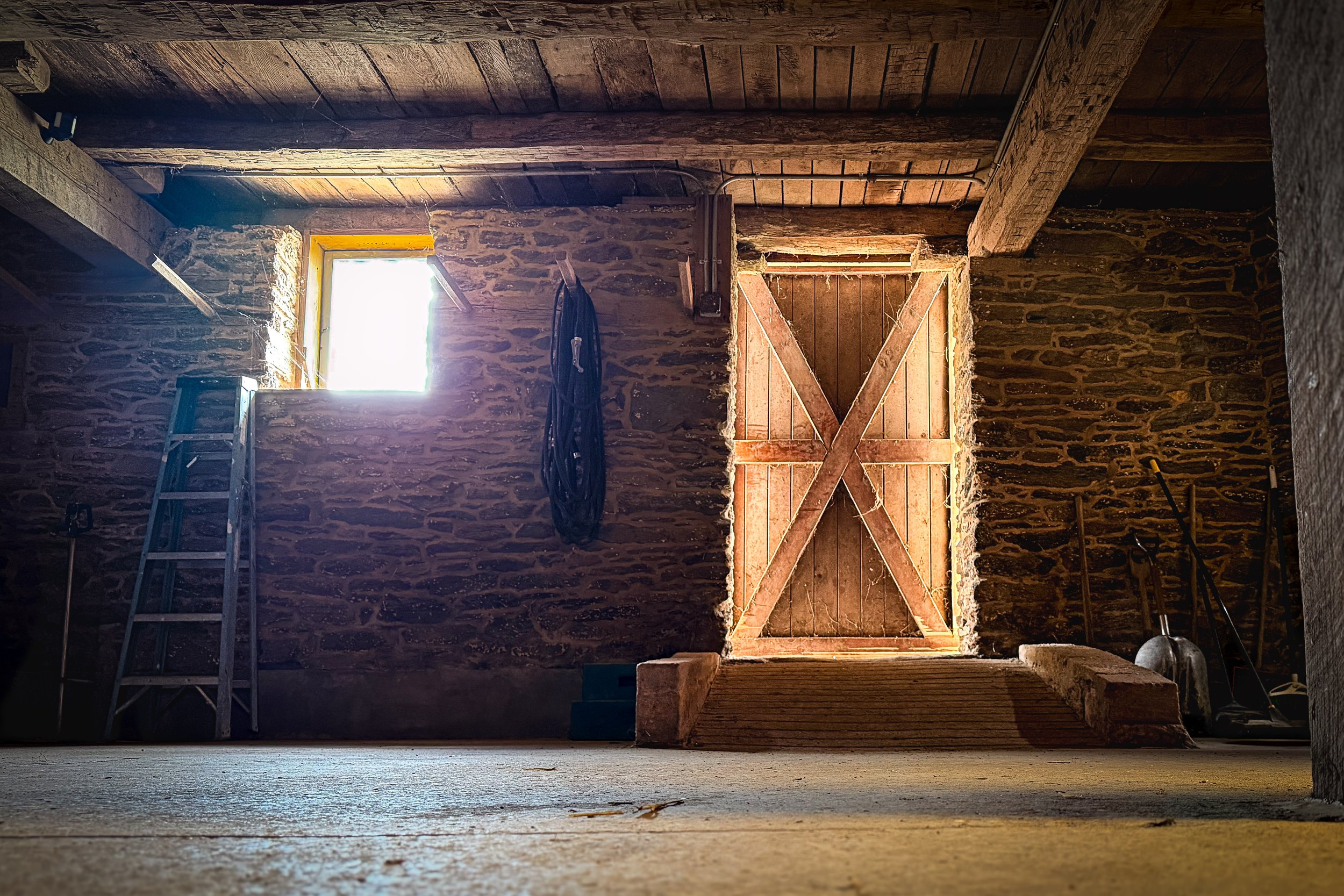 natural light streaming through wooden barn doors illuminating rustic interior, Maryland event and branding photography