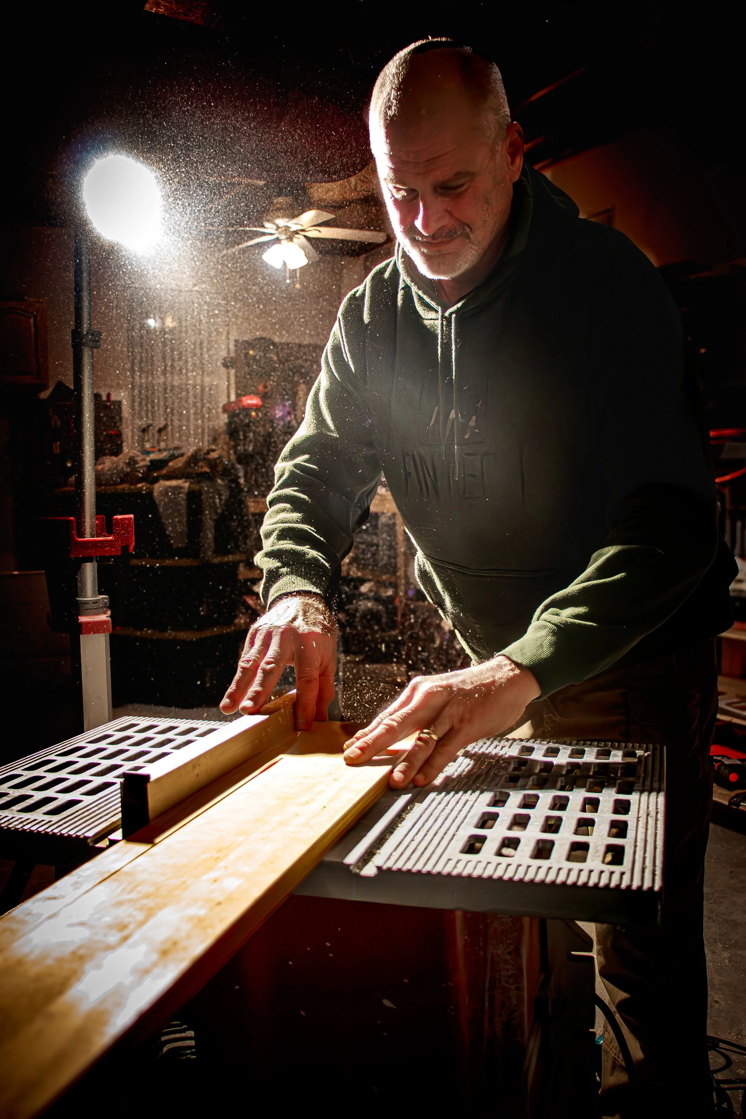 Craftsman cutting wood with a saw in a workshop, documenting small business craftsmanship and woodworking process