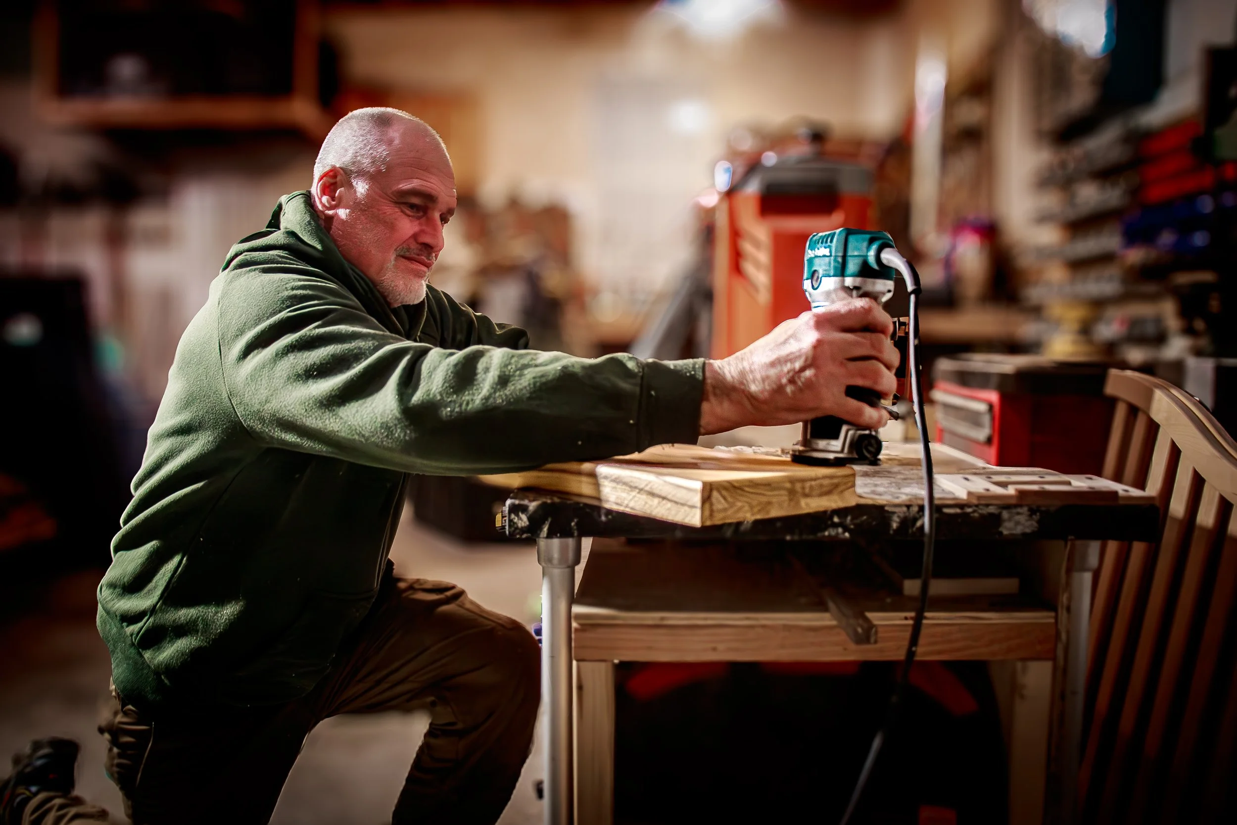 Craftsman cutting wood with miter saw in a workshop, documenting small business craftsmanship and woodworking process