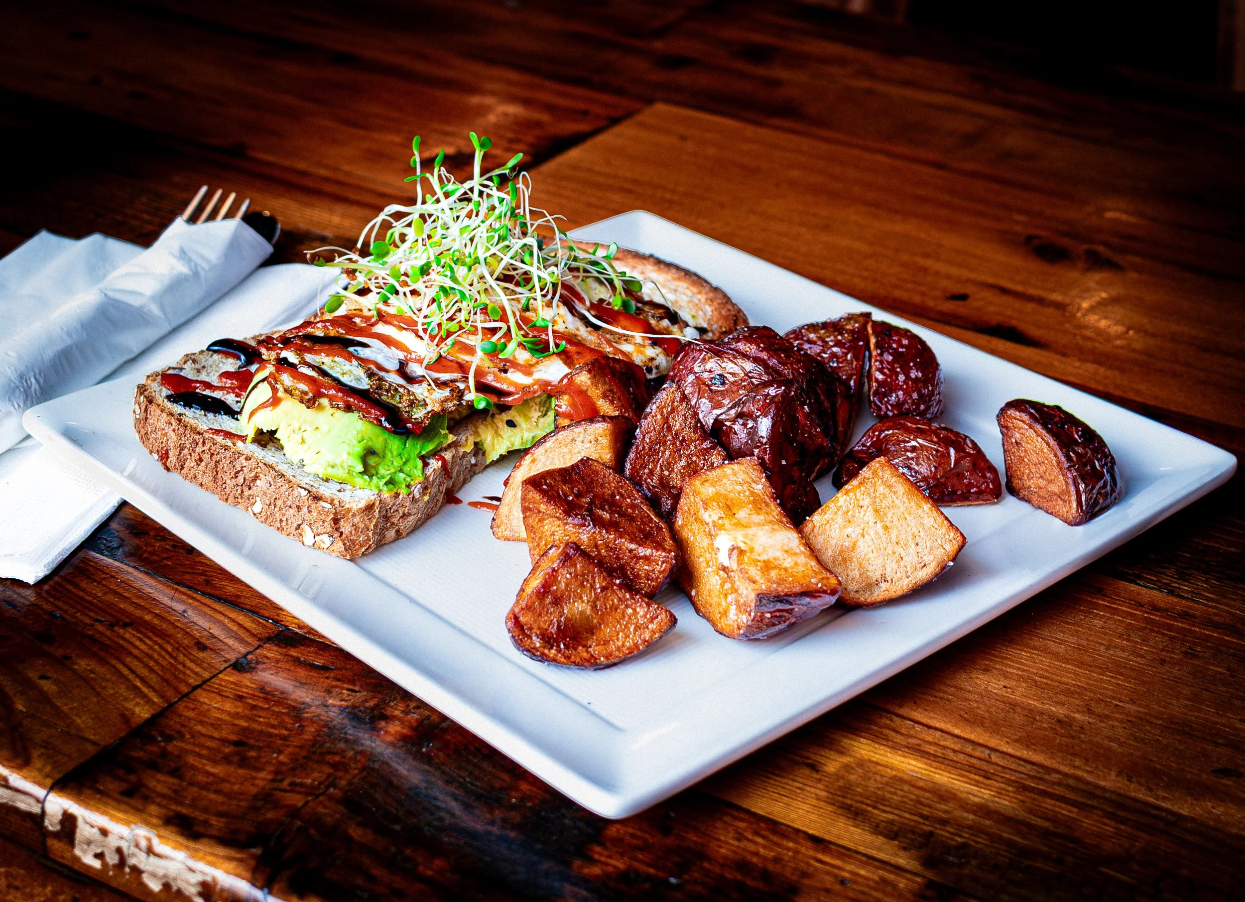 Restaurant food photography for menu and marketing. Avocado Toast with sprouts and homemade potatoes.