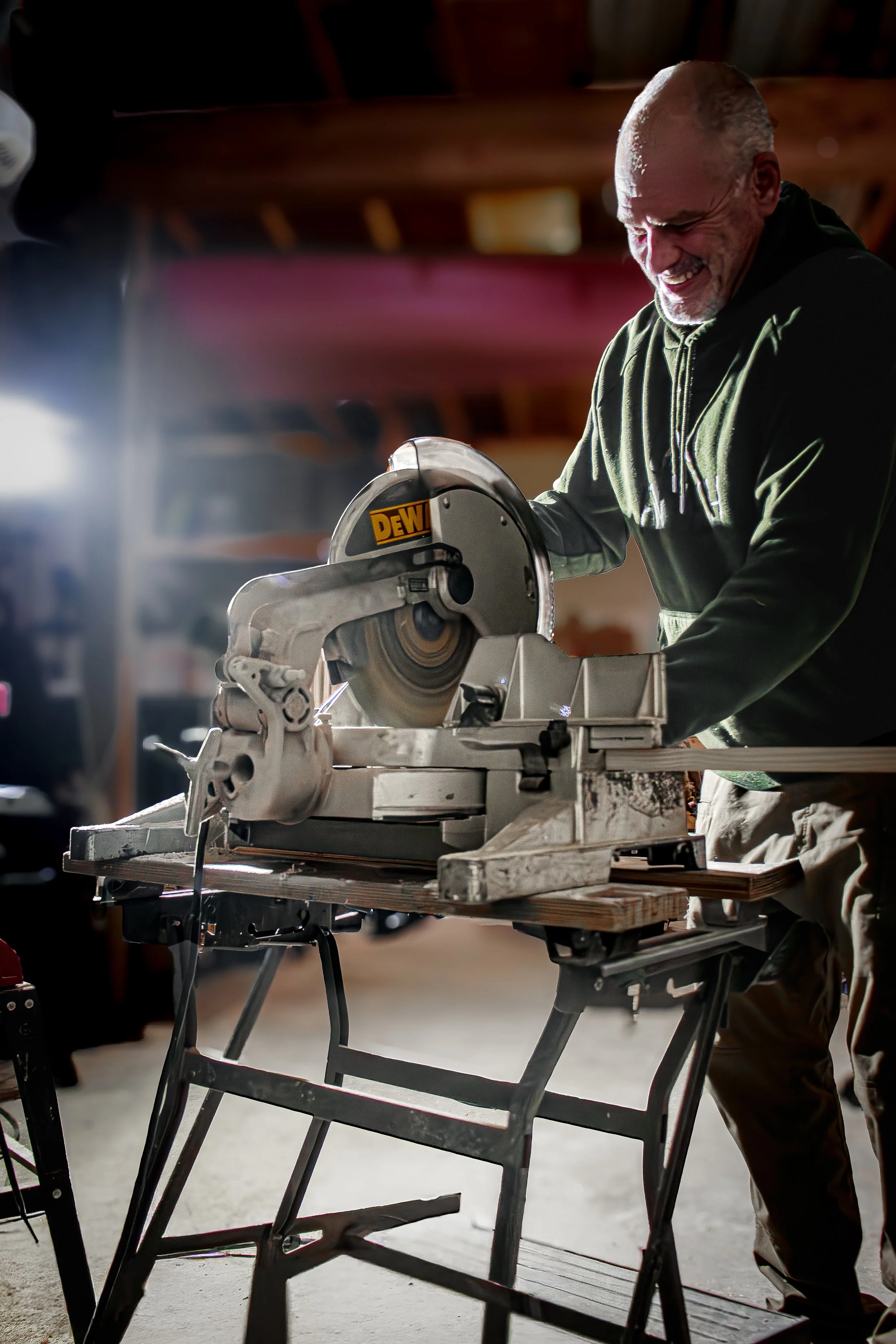 Craftsman cutting wood with a table saw in a workshop, documenting small business craftsmanship and woodworking process in Frederick MD