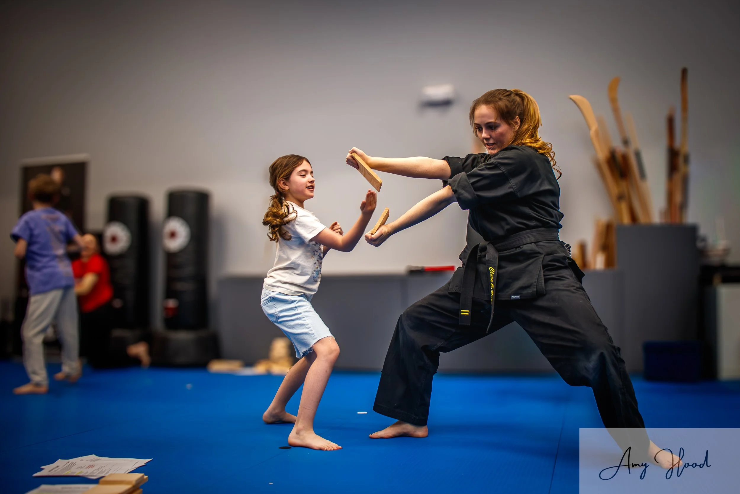 Adult instructor and child practicing martial arts drills together during karate class