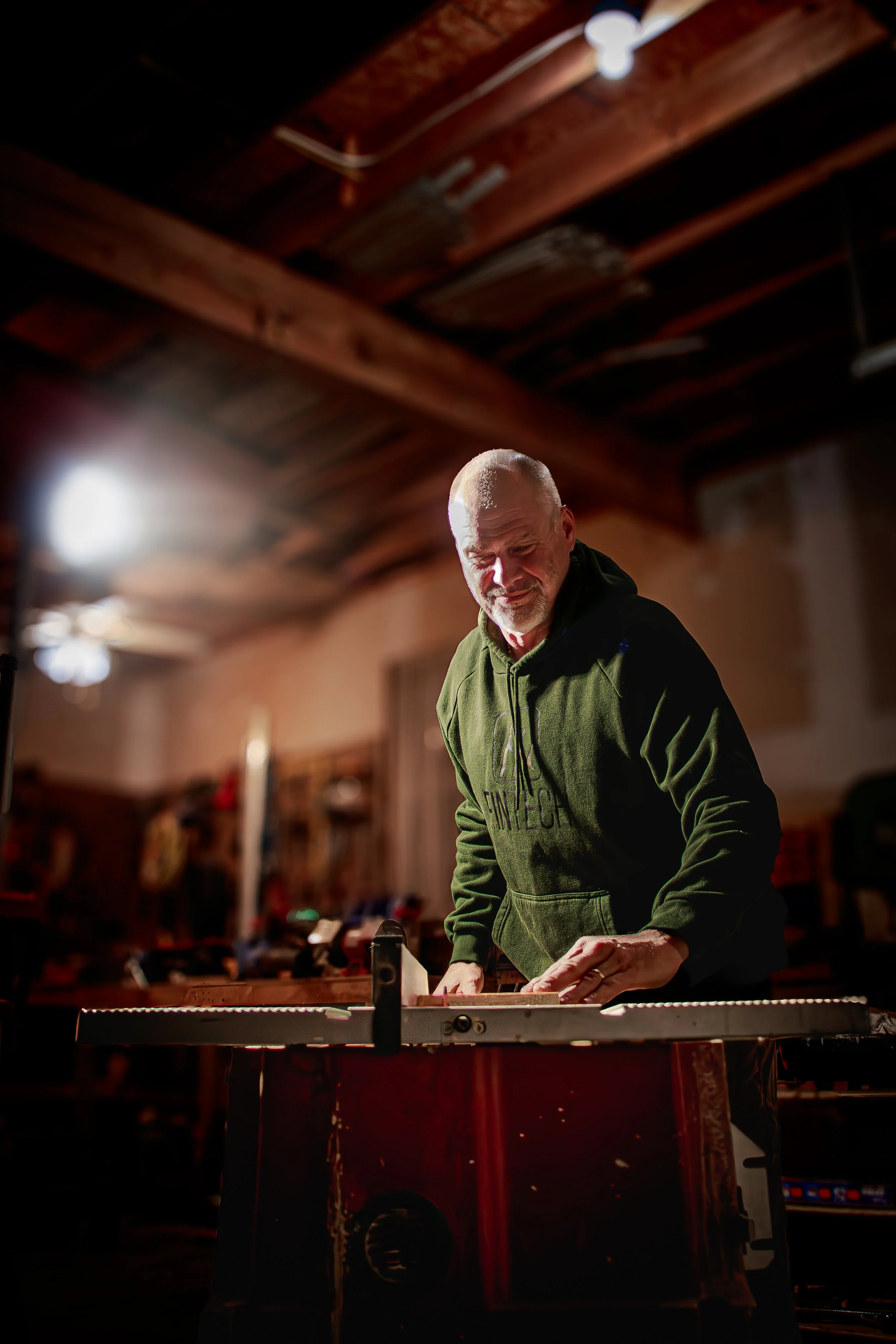 woodworker using a table saw in his home workshop. Documenting small business with photography in Catonsville, MD