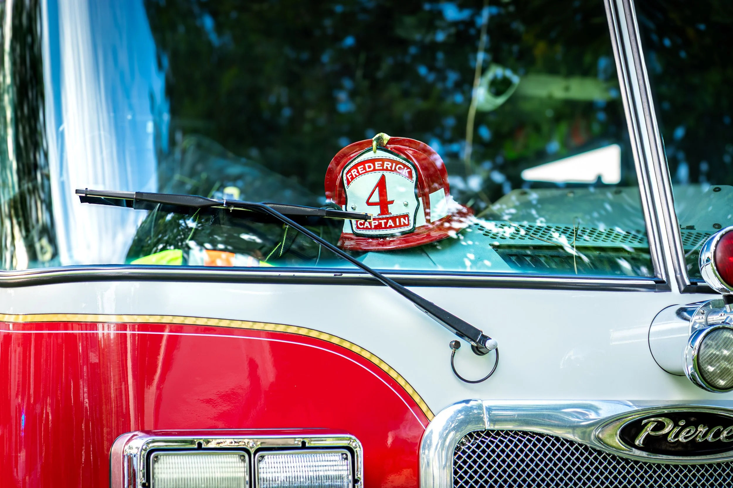 Frederick captains hat reflected in a firetruck vehicle windshield during National Night Out in Frederick, MD