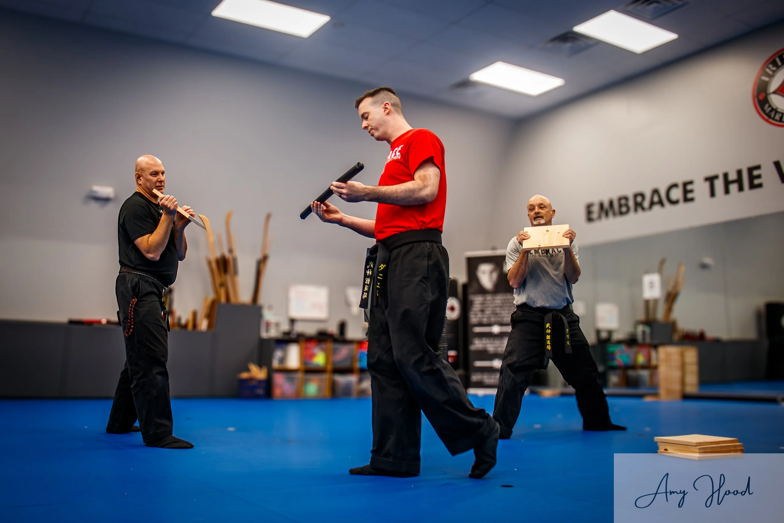 Karate instructor leading a martial arts class and demonstrating technique in a dojo