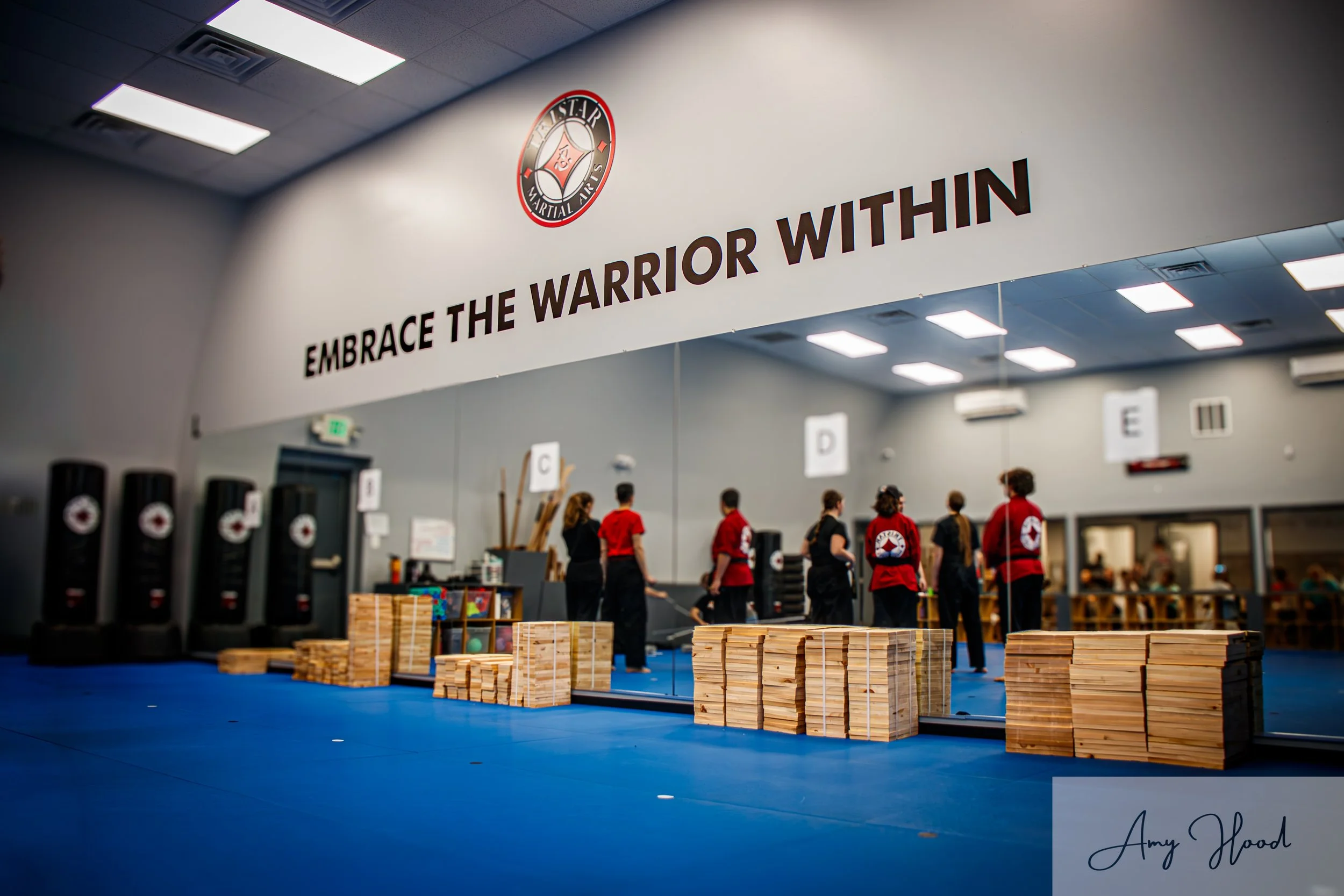Small group reflected in large mirror during an event at a martial arts studio