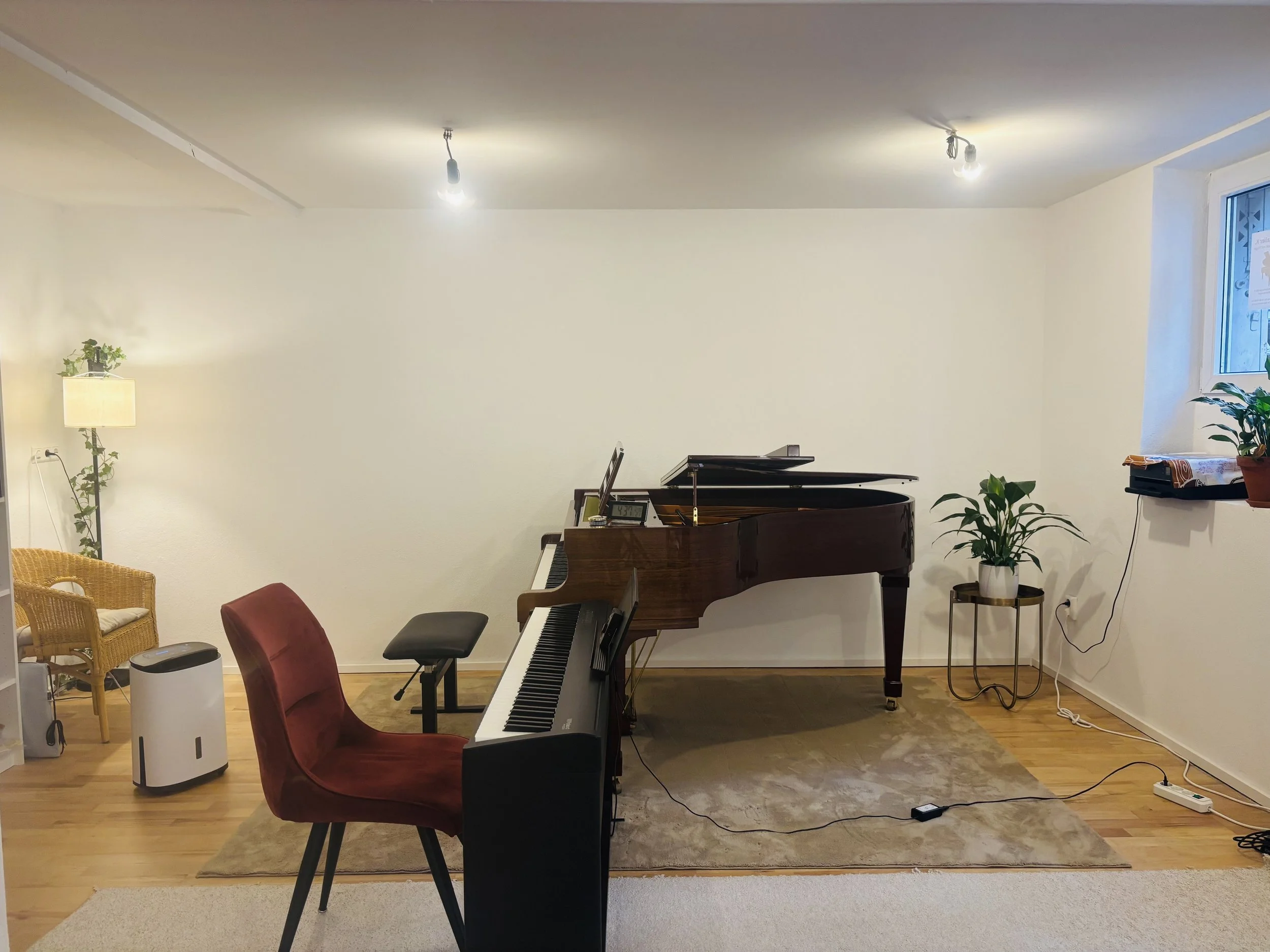 Gemeinsames Musizieren im Klavierunterricht – Schüler am Flügel, Lehrerin am E-Piano