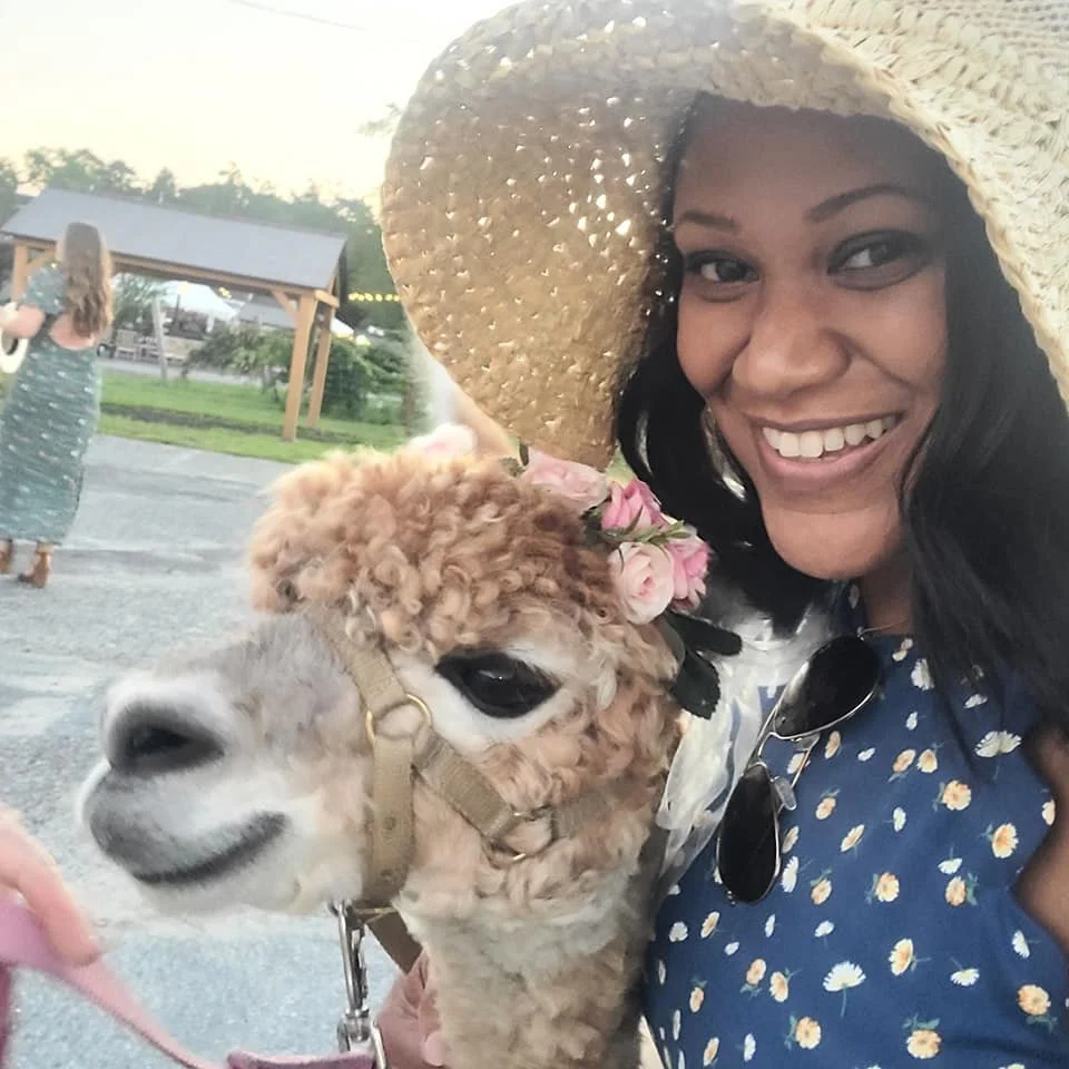 Erica Wright sharing a playful travel moment with a llama