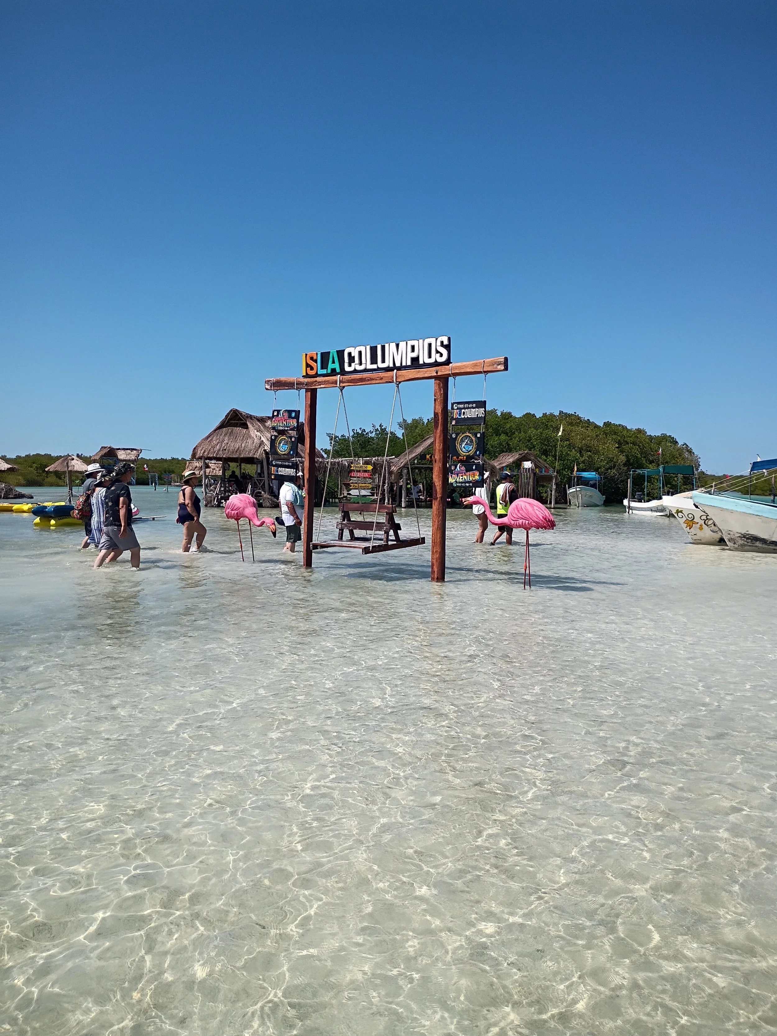 Isla Columpios sign and swings standing in clear shallow water near Chuburná Puerto