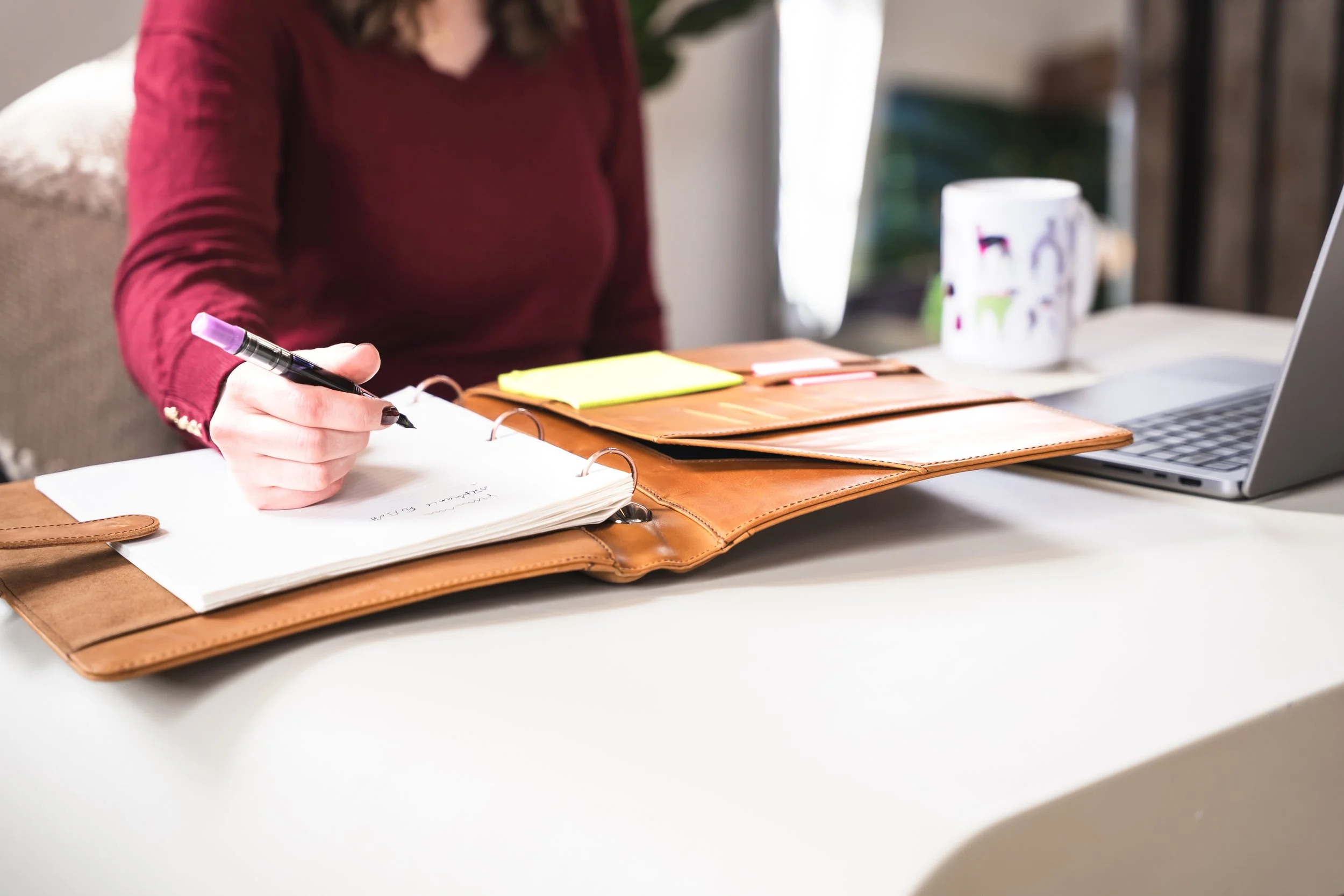A female Toronto online therapist for IBS anxiety and disordered eating writing in her notebook