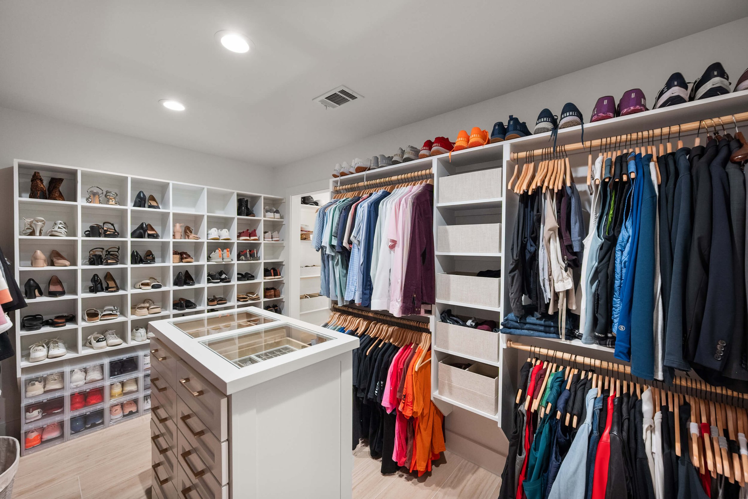 Closet with organized shoes, clothing racks, and storage bins.