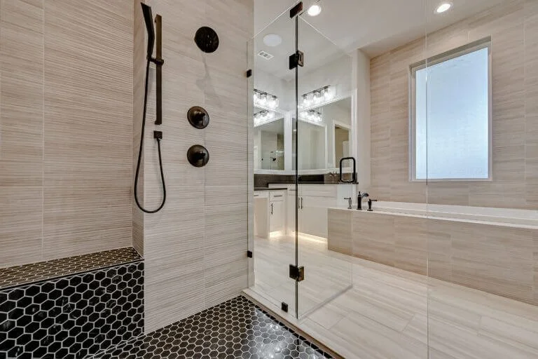 Modern bathroom with a glass shower enclosure, black fixtures, a large window, and a vanity with double sinks in Mansfield, TX.