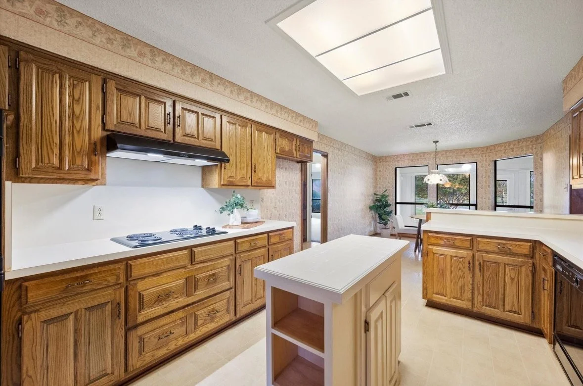 Kitchen with wooden cabinets, a small island, a stove with an exhaust fan, countertops, a dining area with tables and chairs, large windows, and a ceiling light fixture.