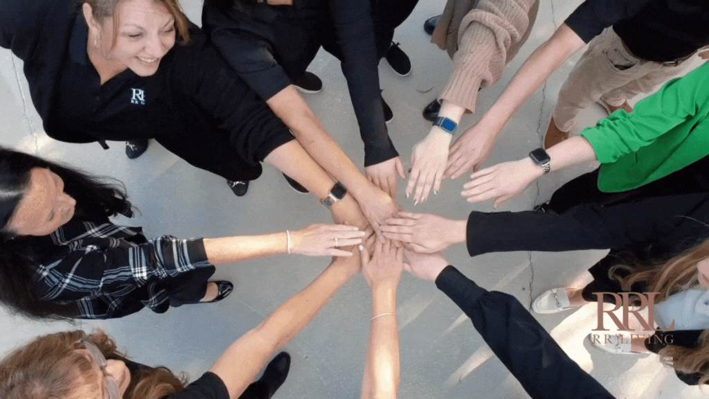Group of diverse people reaching out with hands stacked together.