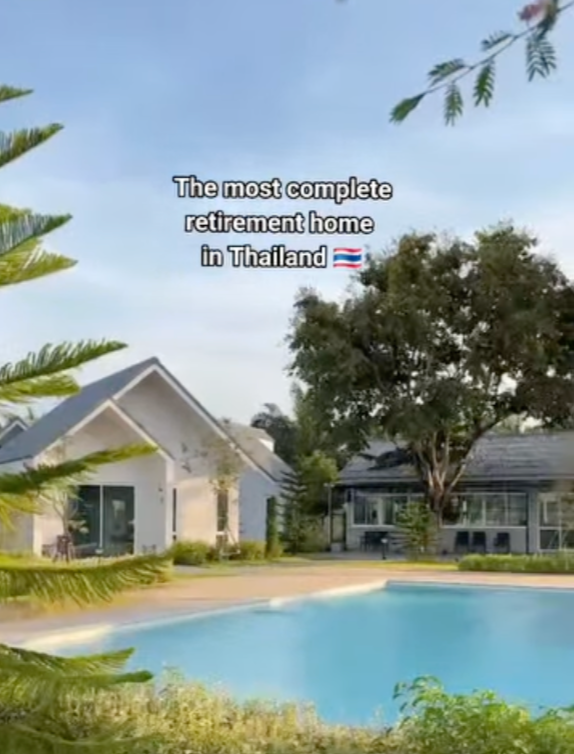 A backyard with a swimming pool, surrounded by trees and modern houses, in Thailand, with the caption 'The most complete retirement home in Thailand' and a Thai flag emoji.   Beach home Thailand 