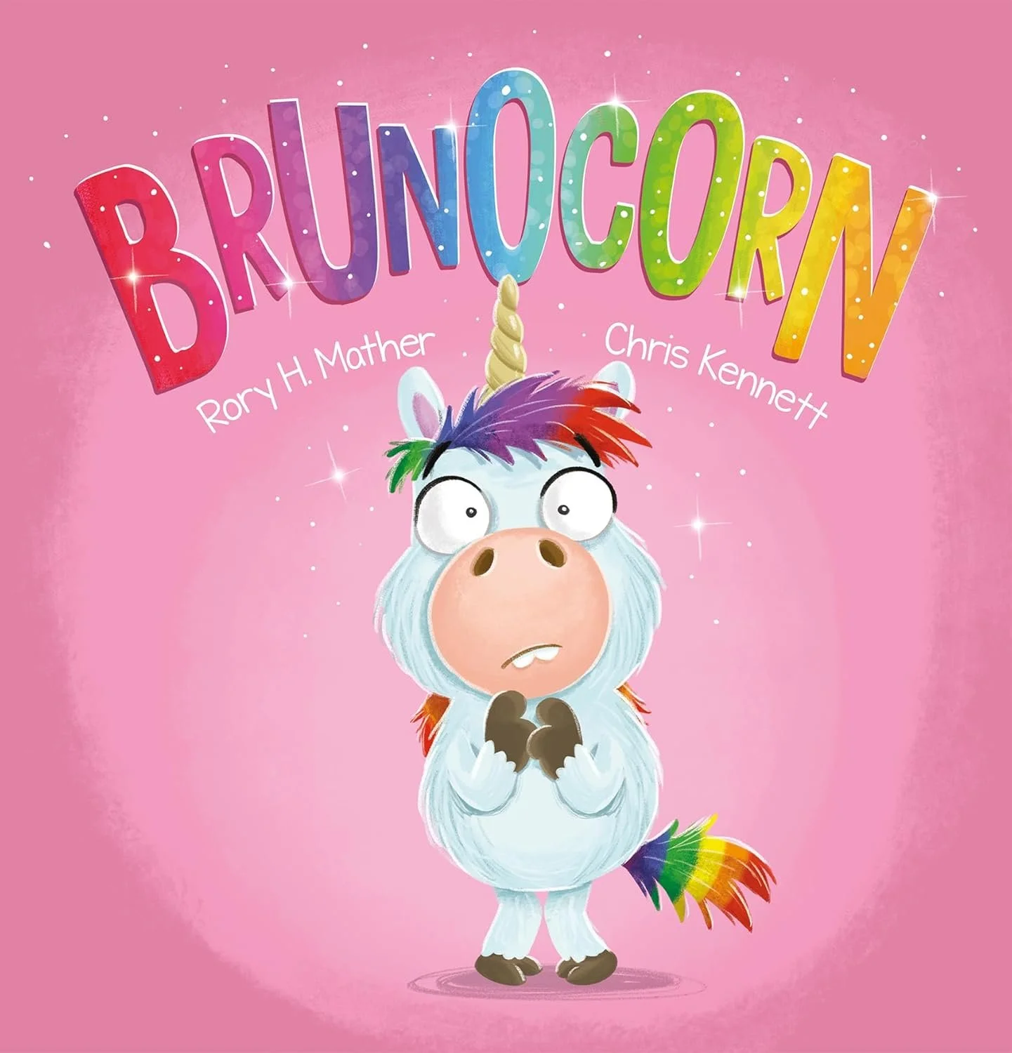 A cartoon unicorn with rainbow-colored mane and tail, standing on a pink background, with the word 'BRUINOCORN' in colorful, glittery letters above it. The unicorn has a surprised or confused expression.
