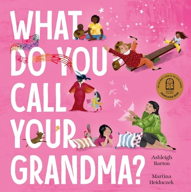 Book cover titled 'What Do You Call Your Grandma?' by Ashleigh Barton and Martina Heiduczek. The cover features colorful illustrations of children and a grandma with a pink background, including a girl playing the guitar, a girl on a seesaw, a girl with a bird, and a girl sitting on the floor.
