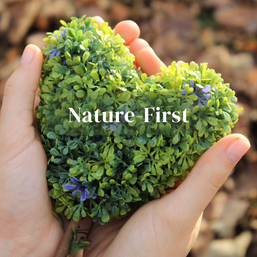 Hands carefully holding heart-shaped greenery with elegant blue flowers, highlighting nature-first