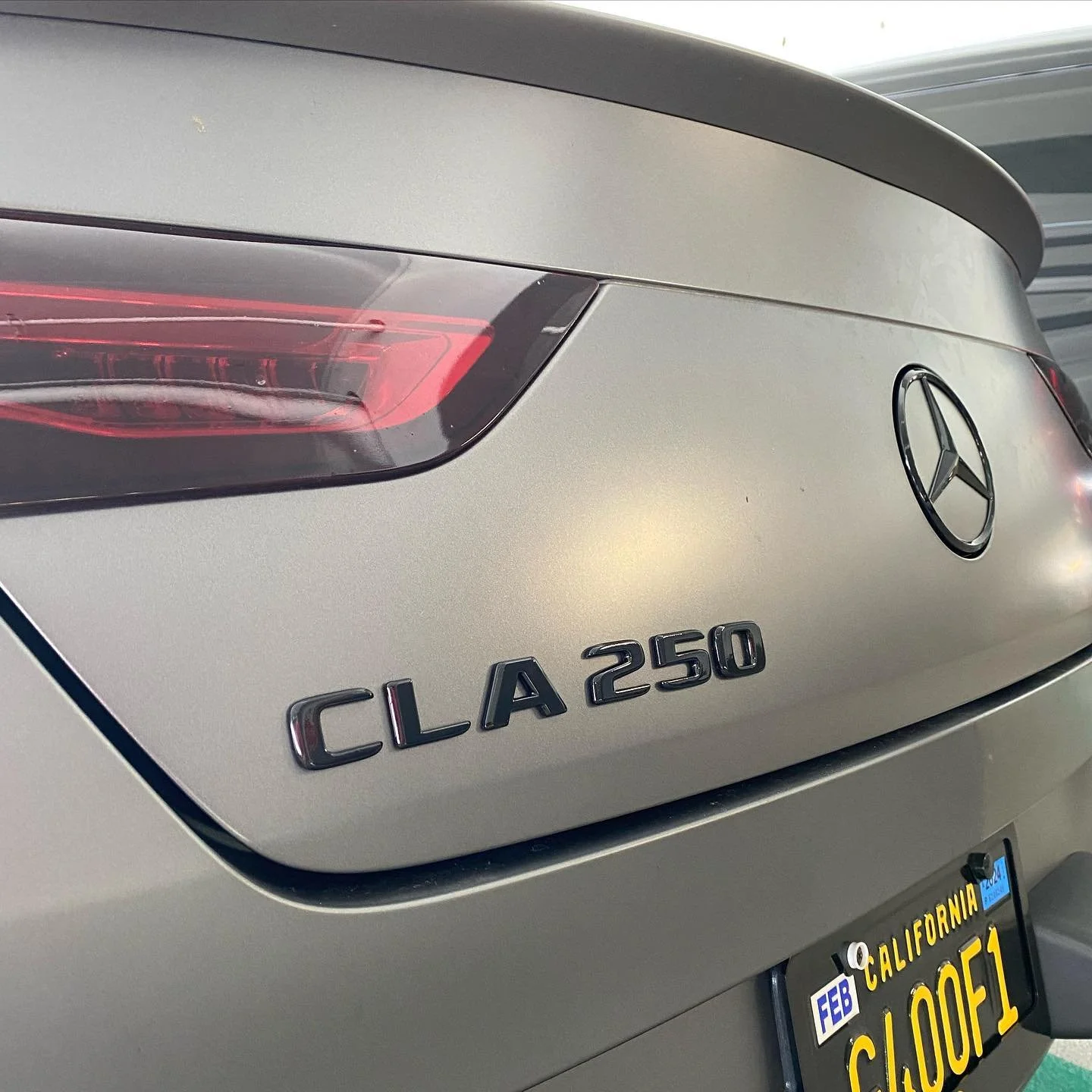 Rear view of a silver Mercedes-Benz CLA 250 with a California license plate reading 'CLOOF1'.
