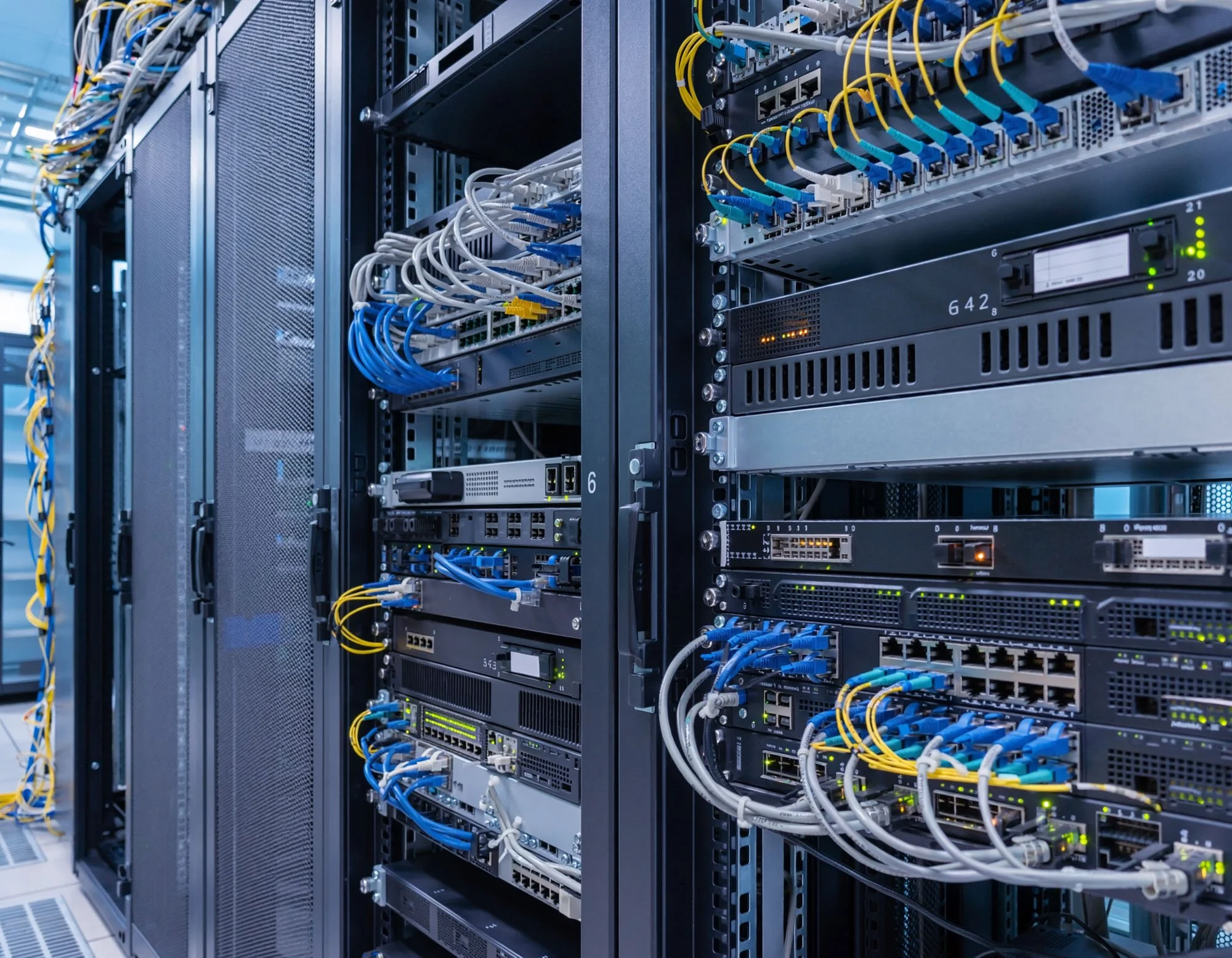Server racks filled with networking equipment, cables, and switches in a data center.