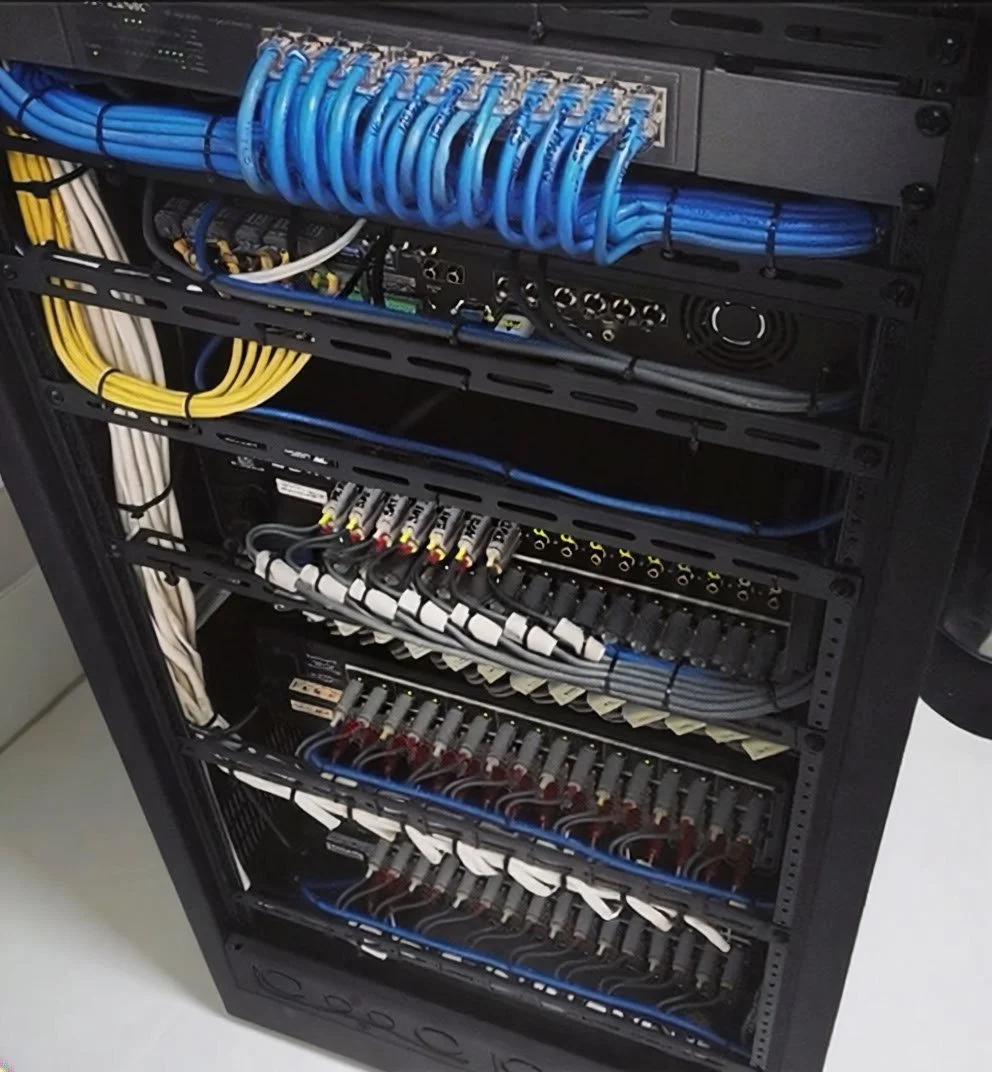 Rack-mounted network server with organized blue, yellow, white, and black Ethernet cables connected to various ports and devices.