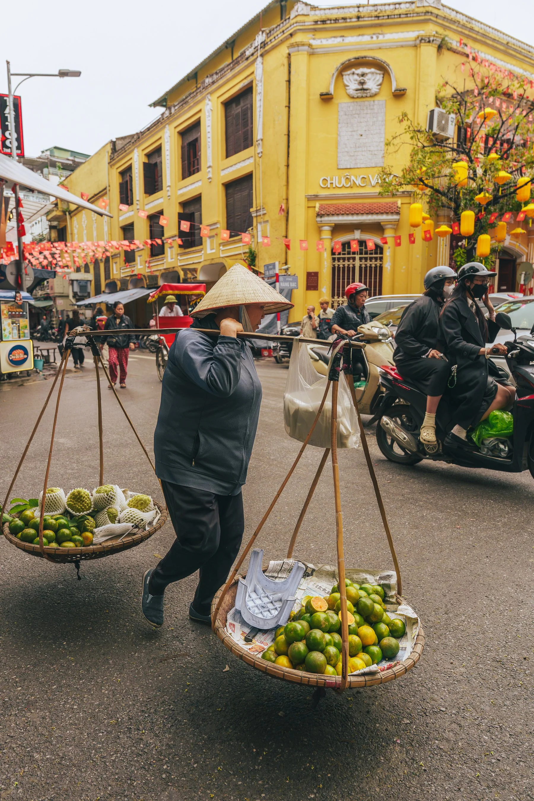 Hanoi in the streets, fruit lady selling rice hat 