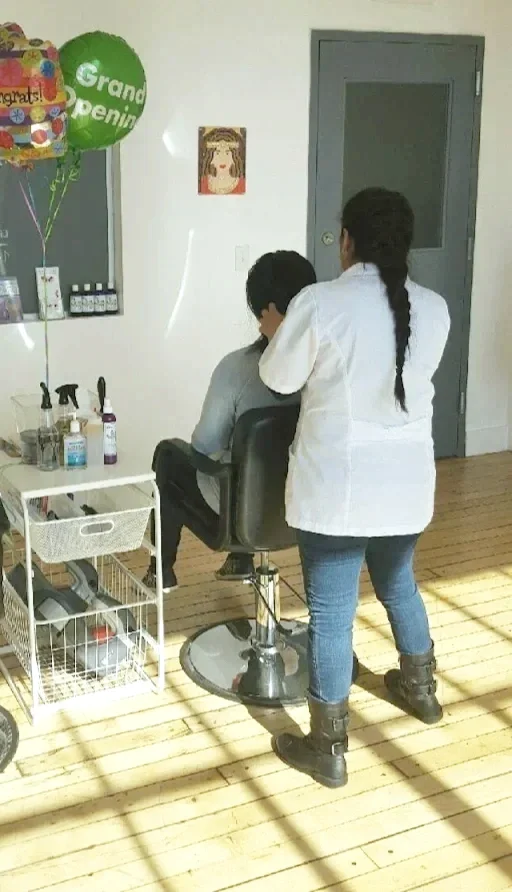 A woman in a white coat checking for lice, lice clinic, lice shampoo, spray, on top of cart.