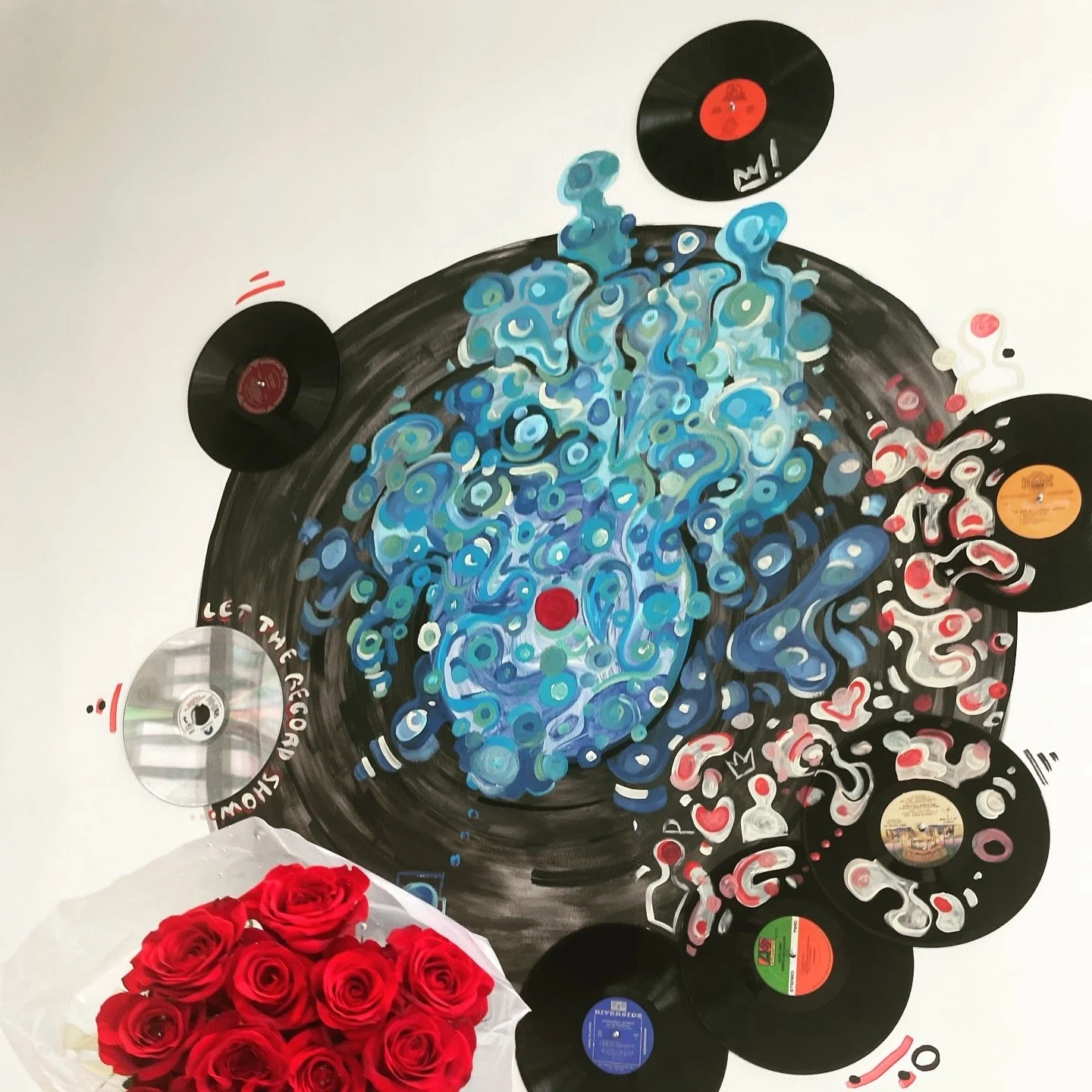 Artwork of a vinyl record player with swirling blue and white designs, surrounded by scattered vinyl records and a bouquet of red roses in the foreground.