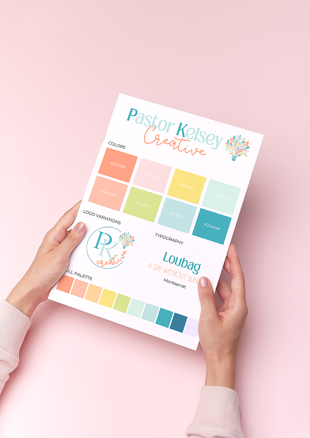 A person holding a branding color palette and logo sheet with pastel colors on a pink background.