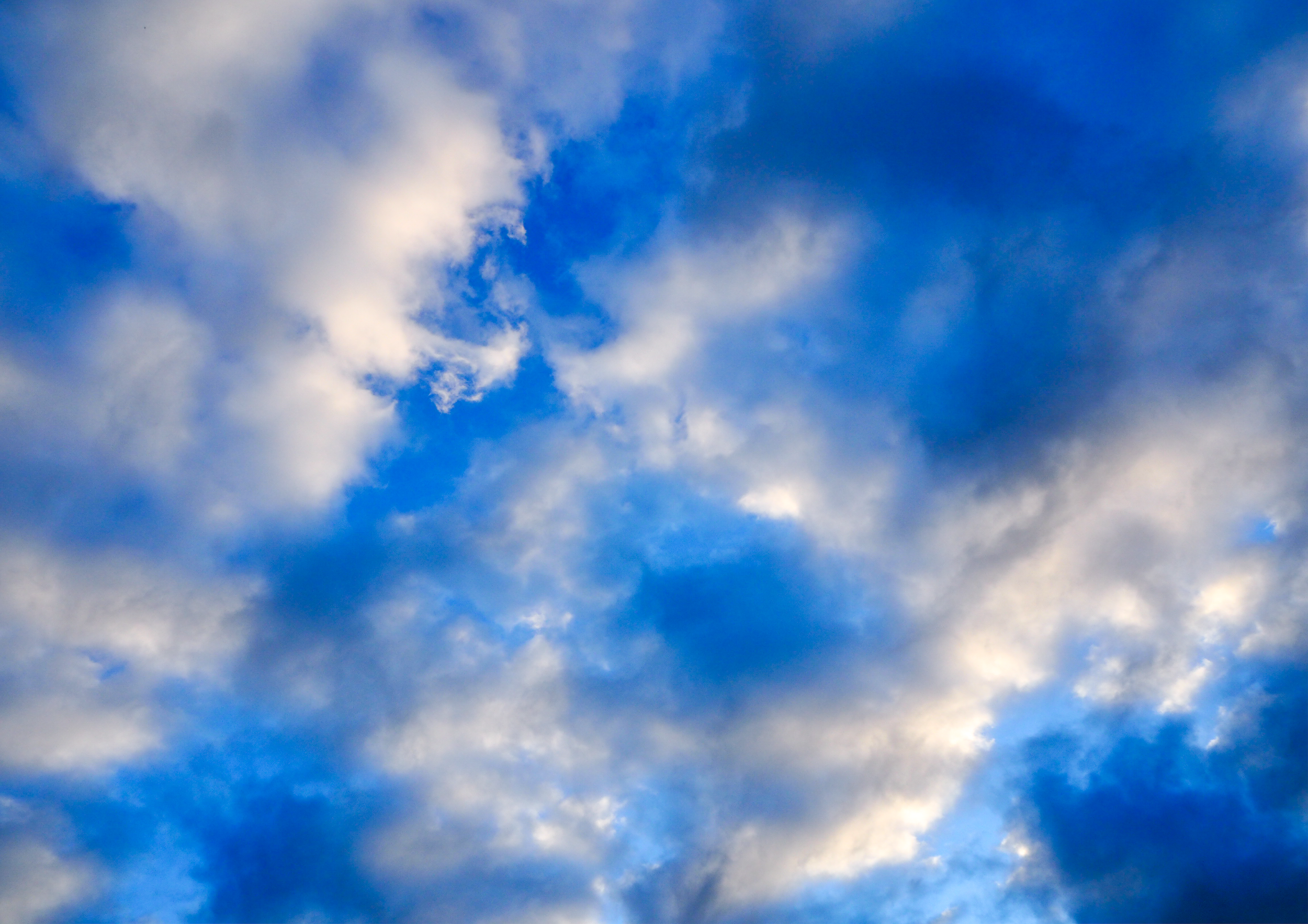 Blue sky with scattered white and gray clouds.