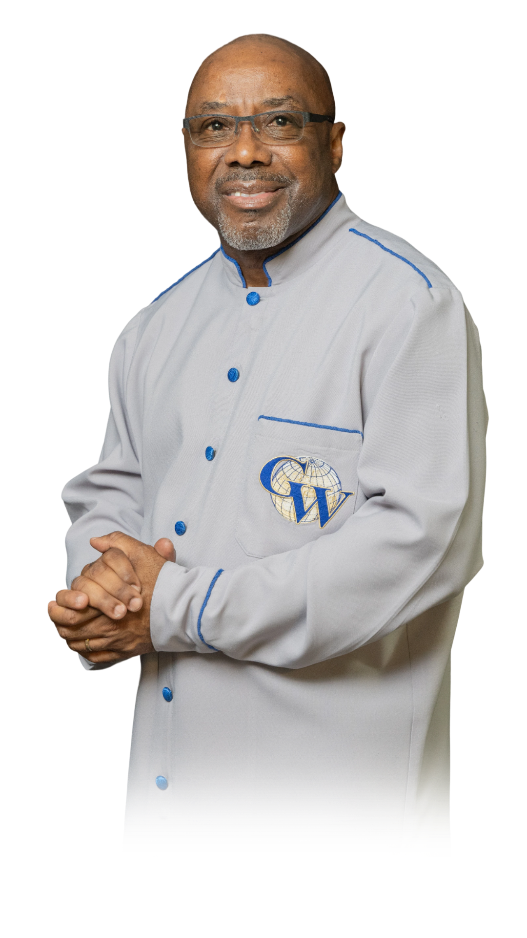 A man wearing glasses and a white jacket with blue buttons and piping, standing with his hands clasped, smiling at the camera. The jacket features a logo with a globe, a letter C, and a letter W.
