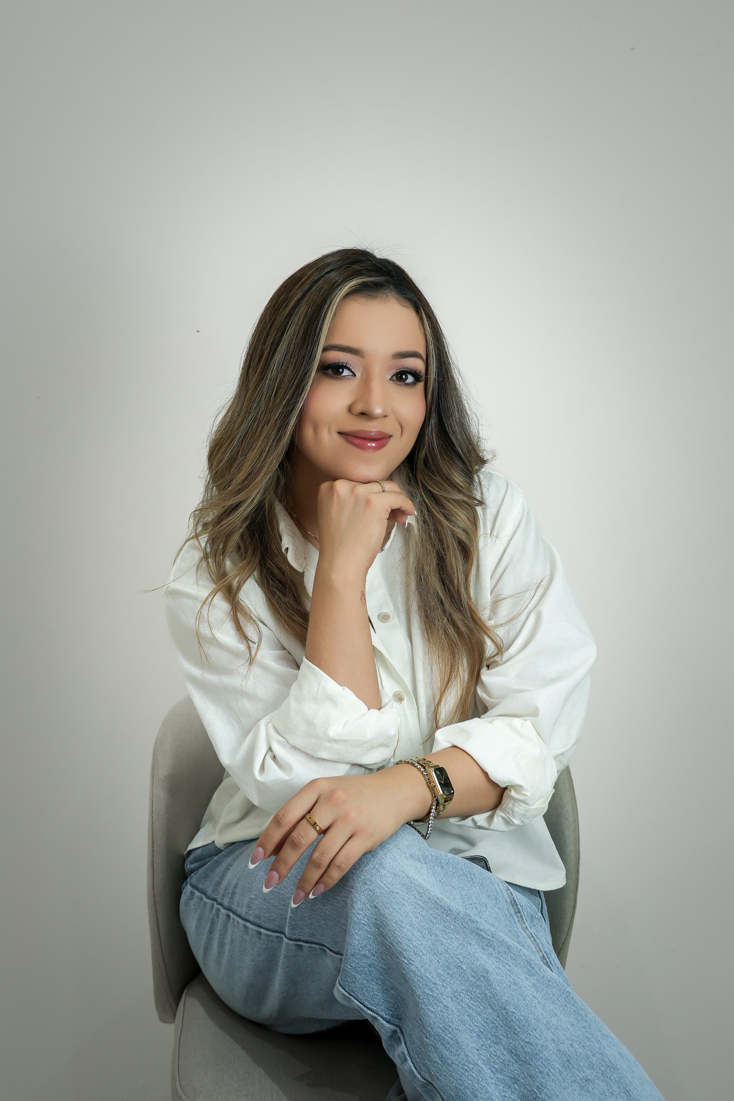 Graciela, especialista en manicure ruso y nail art de Graciela Nails en El Salvador, sonriendo con la mano en la barbilla.