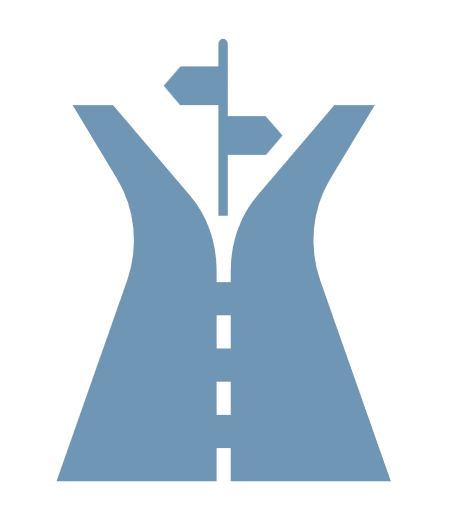 A building on a grassy hillside with snow-capped mountains in the background under a cloudy sky.