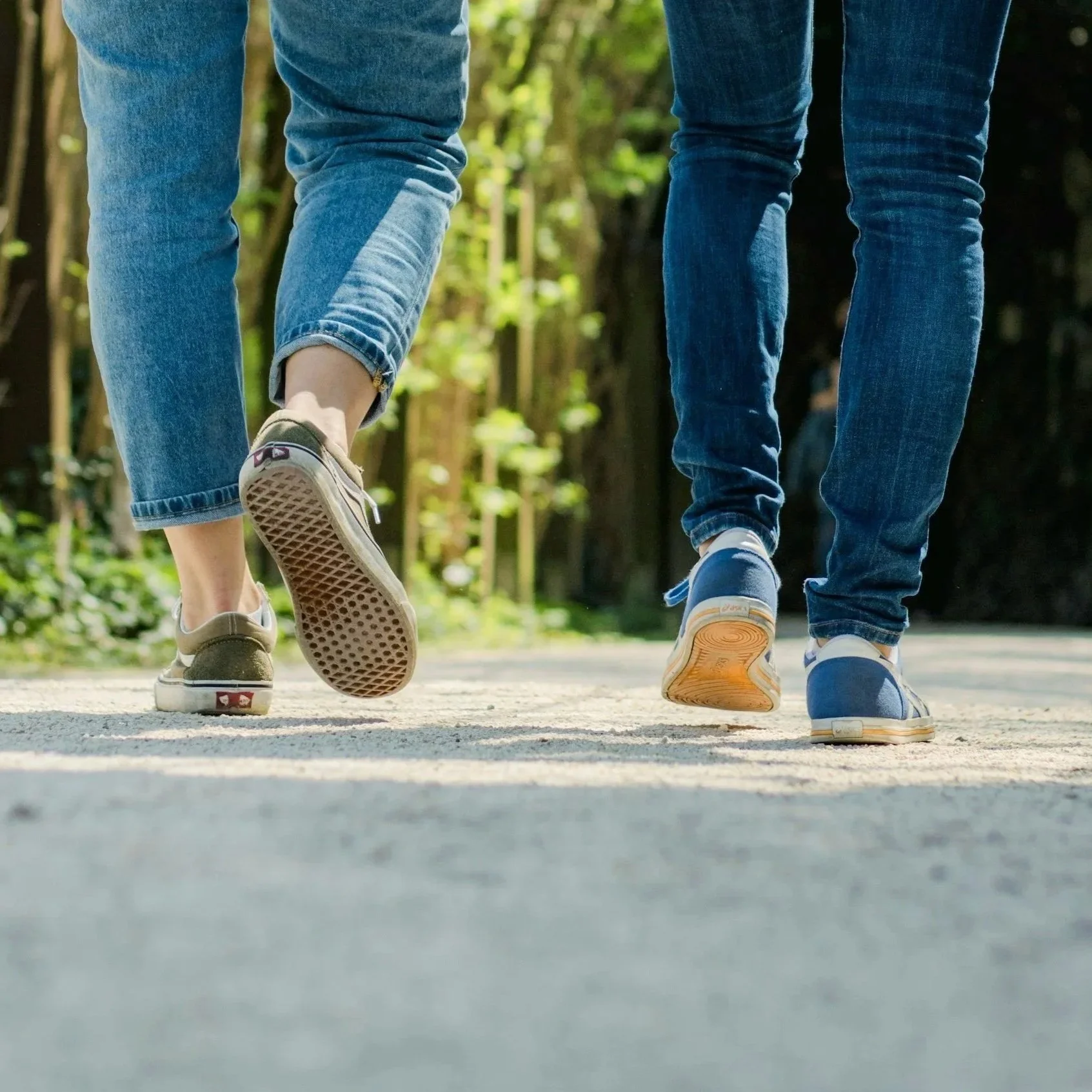 two women walking side by side together on a path