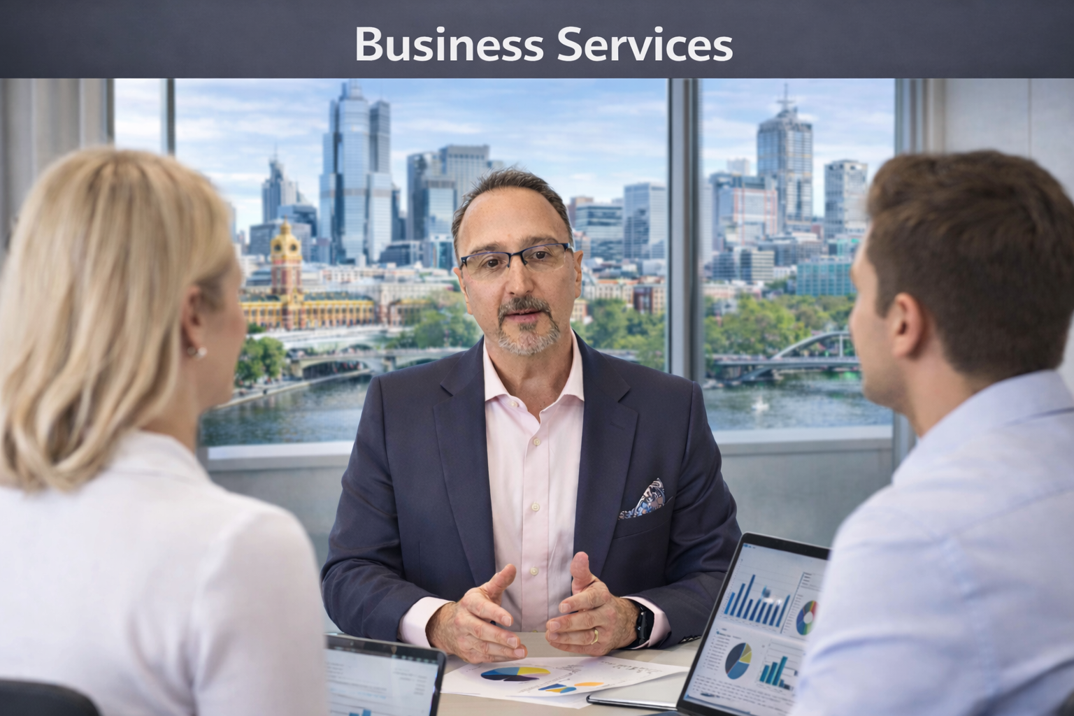 Three business professionals having a meeting in a modern office with a city skyline view, including tall buildings and a river.