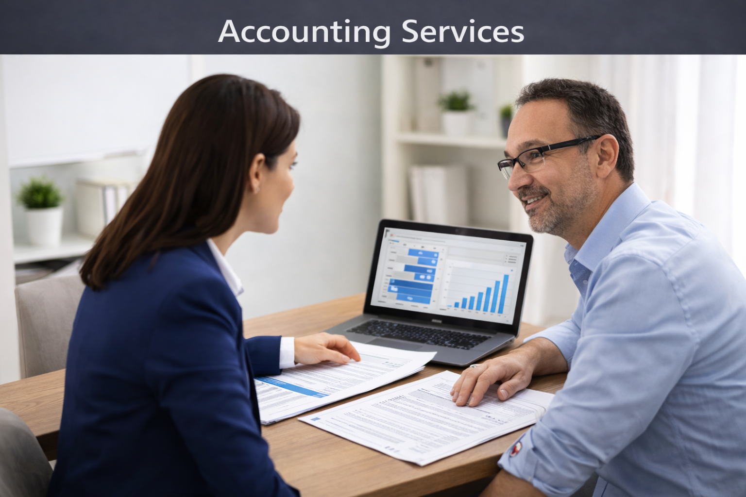 Two professionals in an office, one woman and one man, discussing documents during a meeting about accounting services, with charts displayed on a laptop screen.