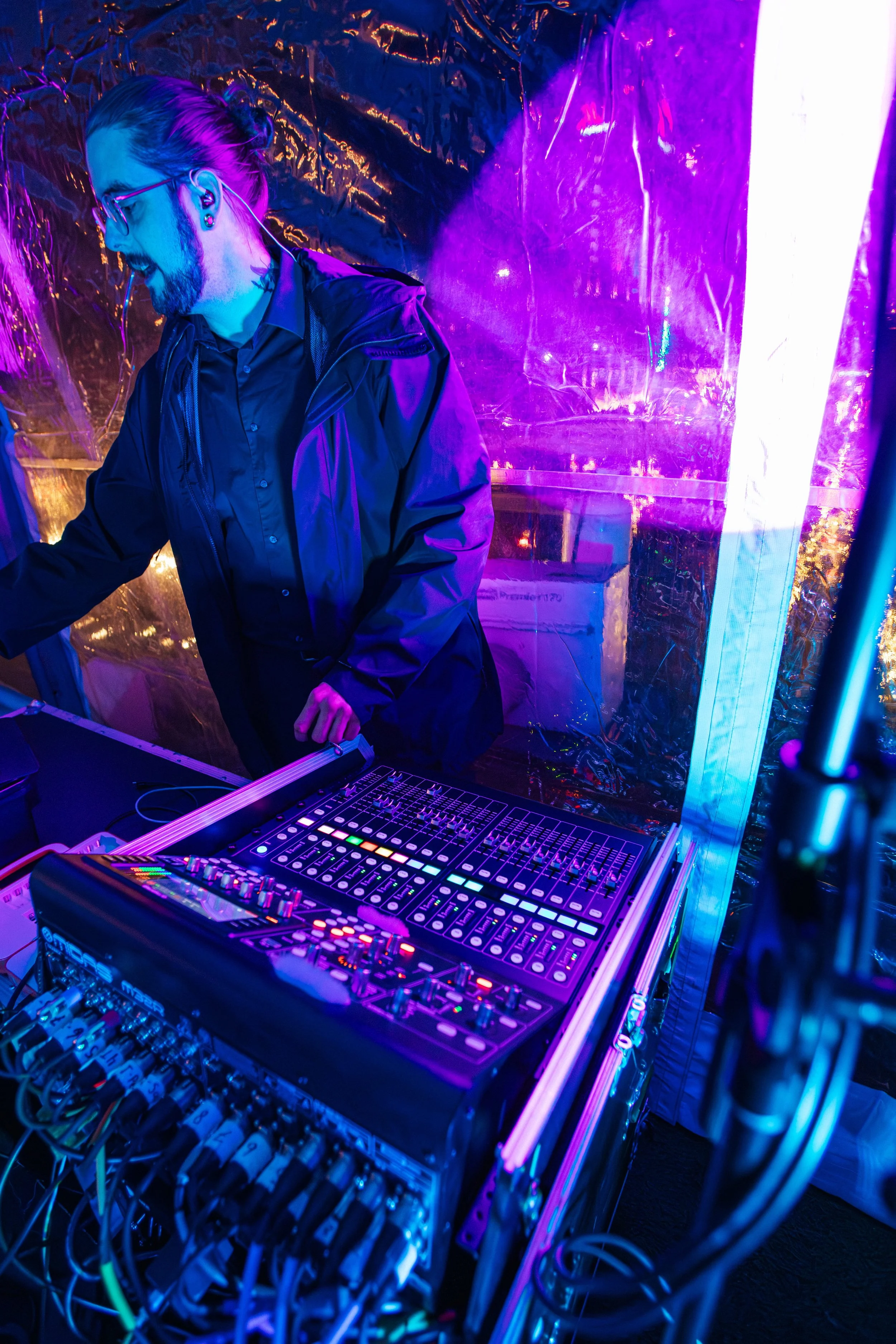 RDAV technician managing sound equipment under purple stage lighting