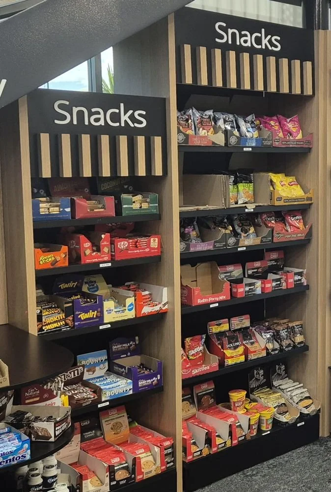 Micro market snack shelving stocked with bars, chips and confectionery